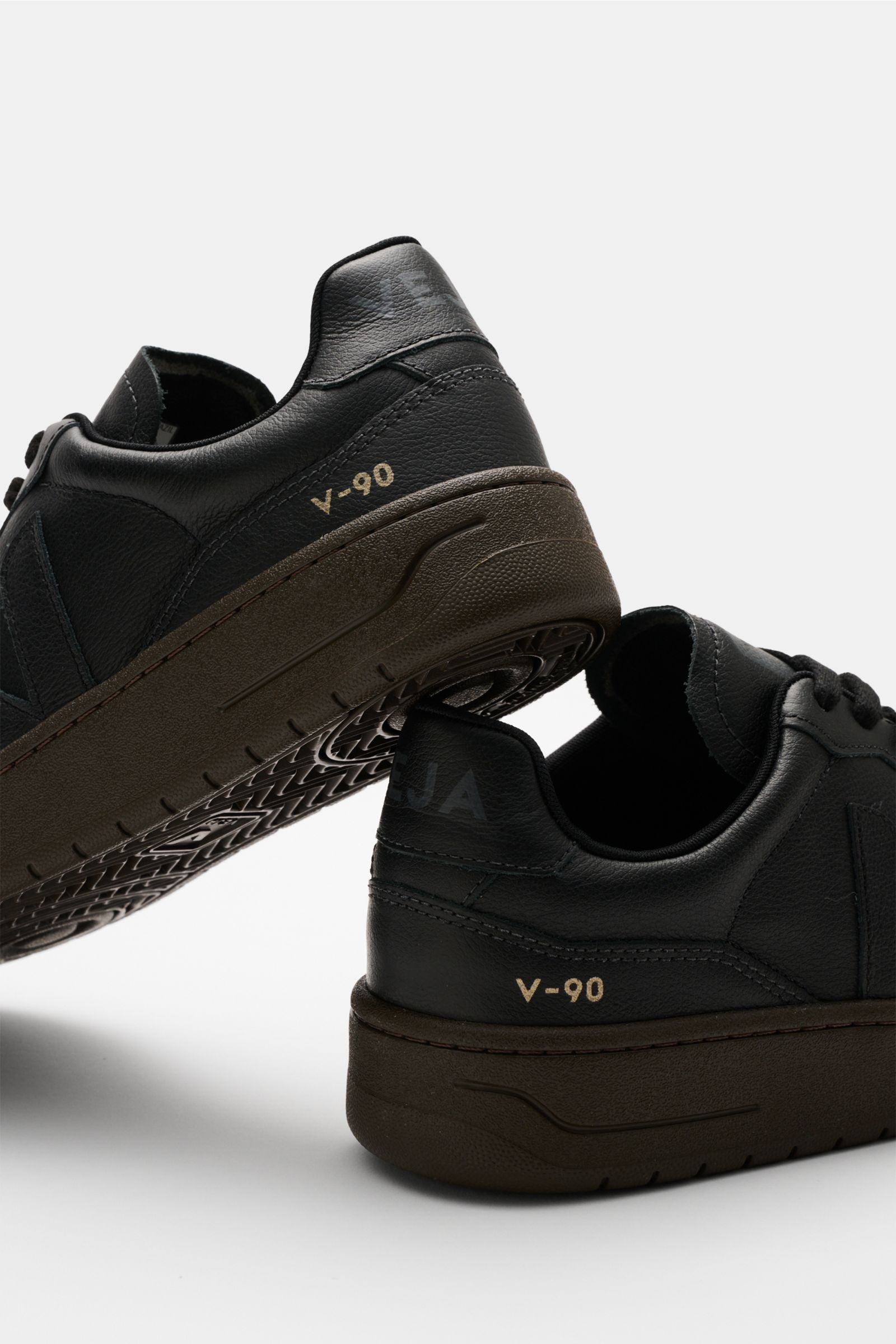 Veja Sneaker 'V-90 O.T. Leather' offwhite/hellgrau/graublau shown from rear and bottom angles, made with sustainable leather, perforated rounded toe, seven-hole lacing, padded collar with logo, tonal V-overlay, jersey lining, and recycled rubber sole. Inn