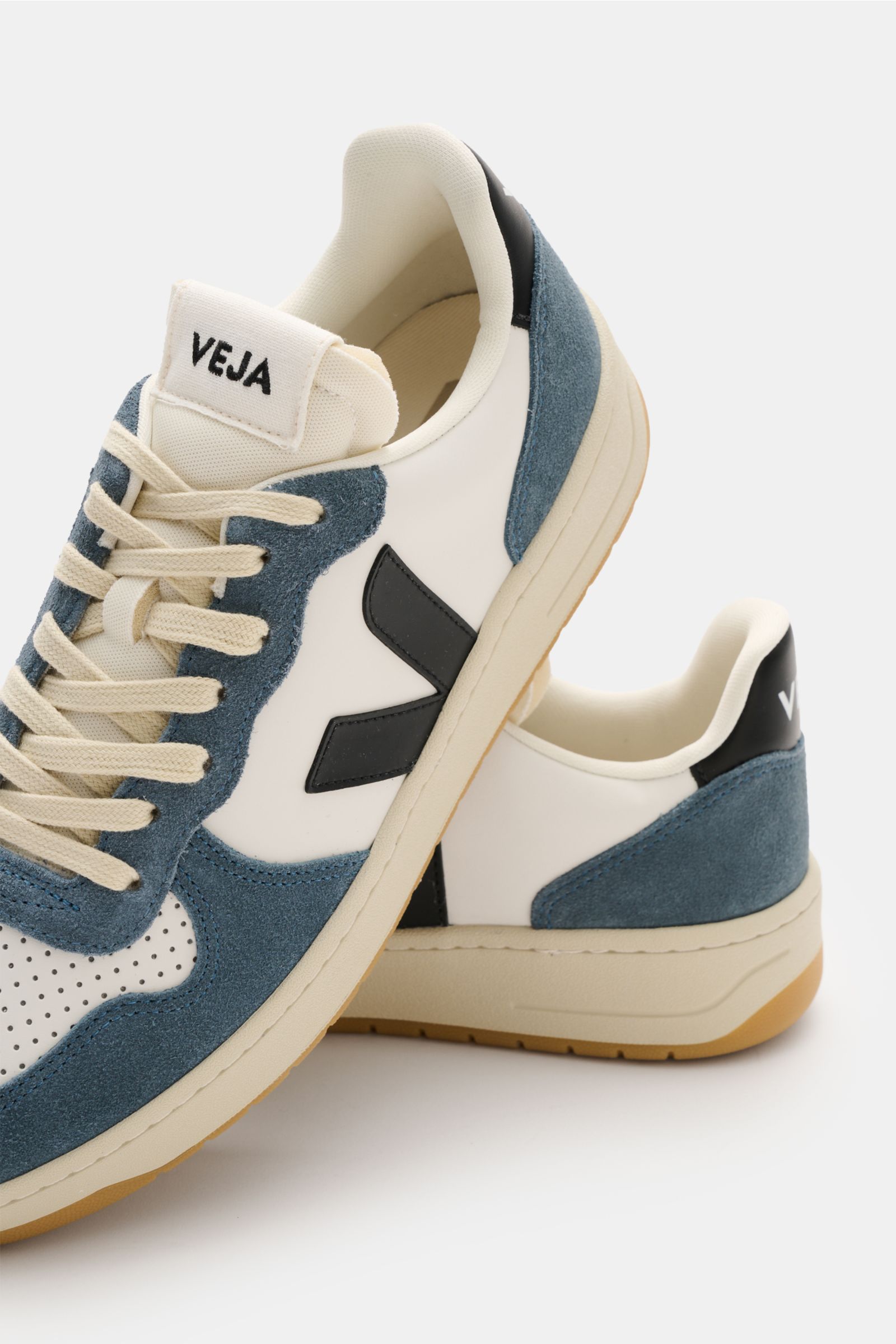 Veja Sneaker 'V-10' pastellgrün/offwhite/creme shown from side and front angle, featuring sustainable leather, perforated round toe, seven-hole lacing, padded collar with logo, web label on tongue, V-overlay, jersey lining, and recycled rubber sole. Innov