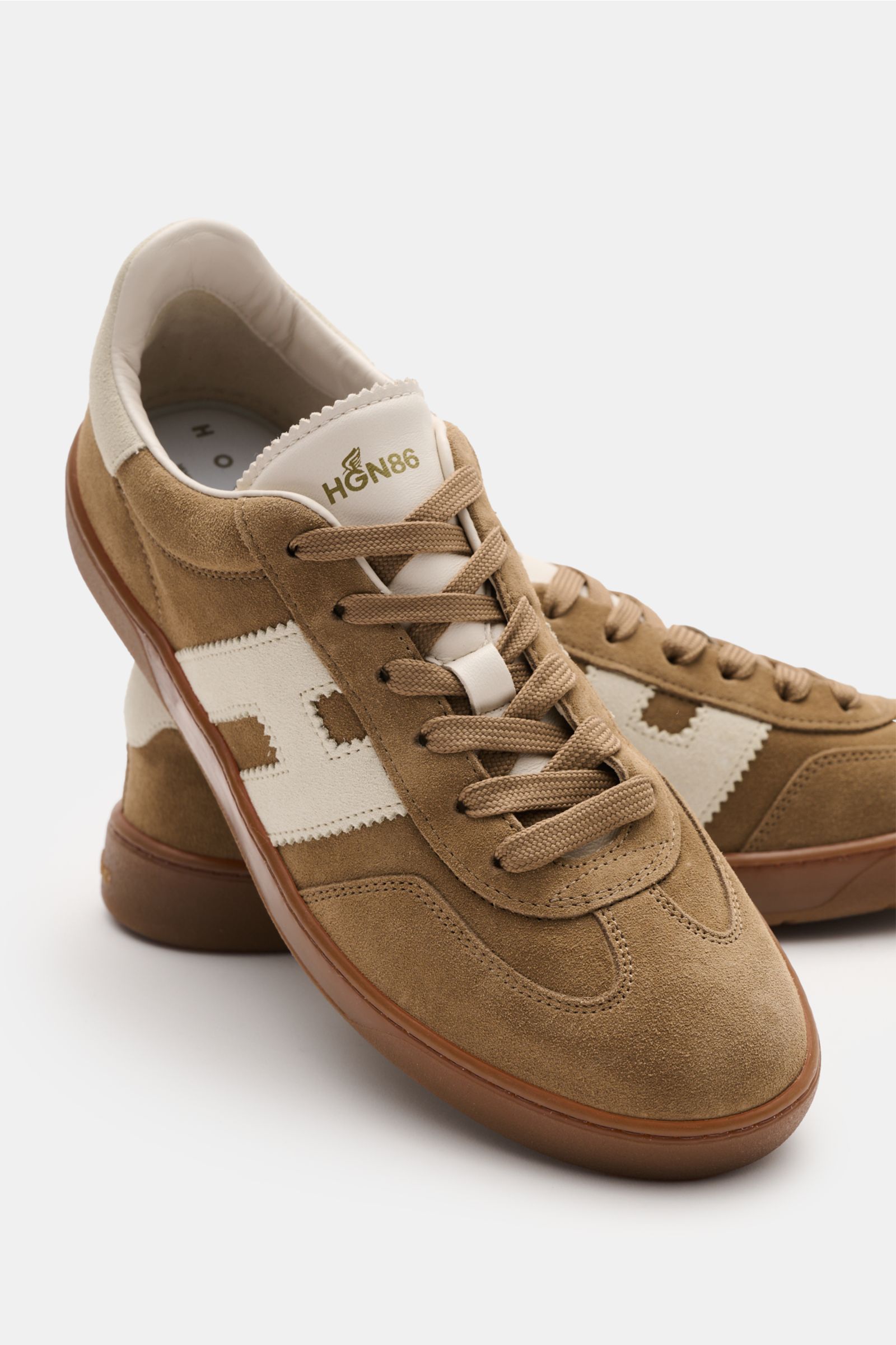 Close-up front-side view of Hogan Sneaker 'Cool' braun in fine brown velour leather with white H-shaped overlay, six-hole lacing, and cushioned collar.

Retro-Design trifft Komfort: Der Sneaker 'Cool' mit dem markentypischen H-förmigen Overlay von HOGA