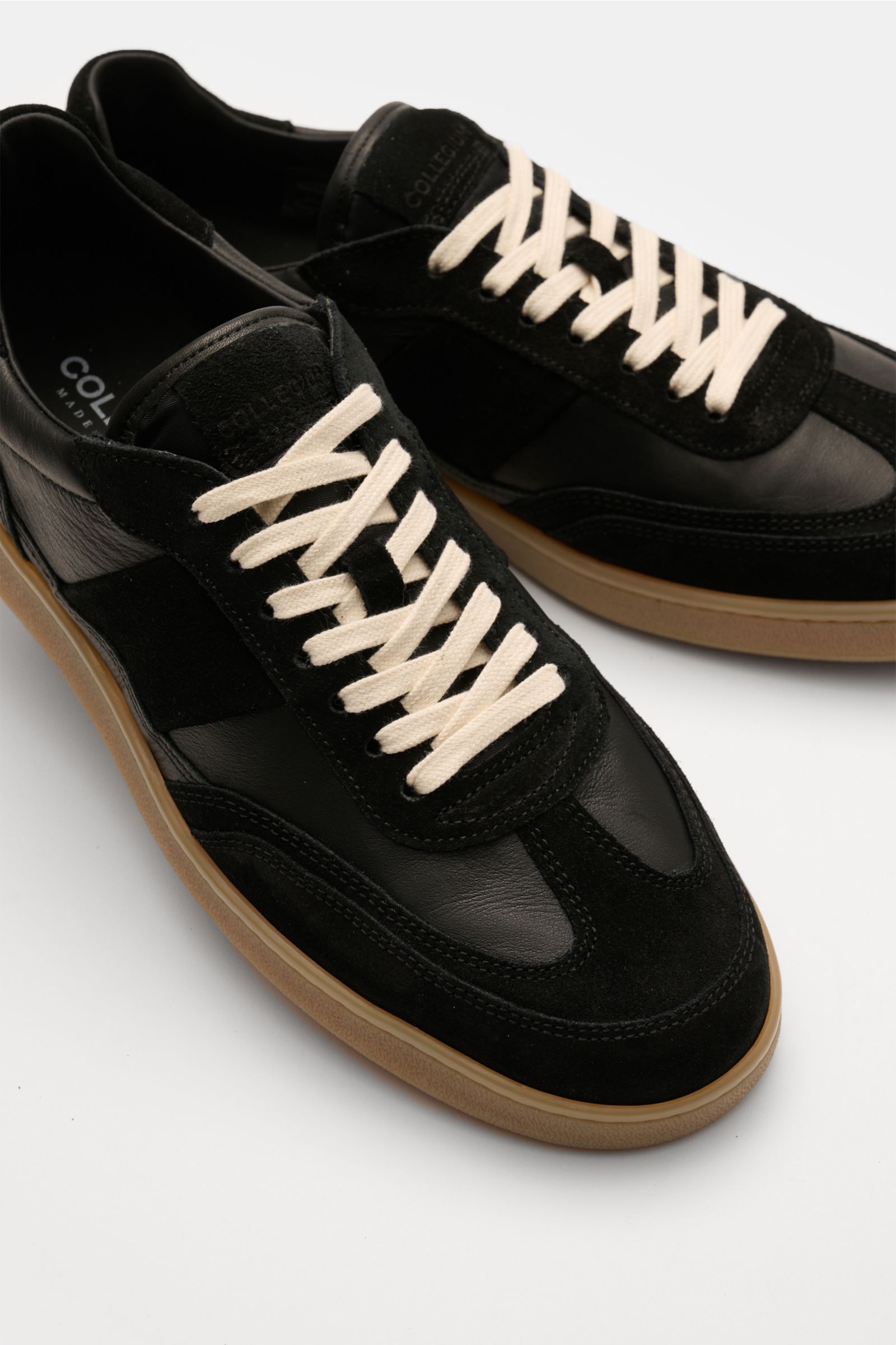 Collegium Sneaker 'Pillar Court II' schwarz, seitliche Nahaufnahme, aus fein genarbtem Glattleder, Velours- und Nubuk-Overlays, weiße Schnürung, braune Gummisohle.