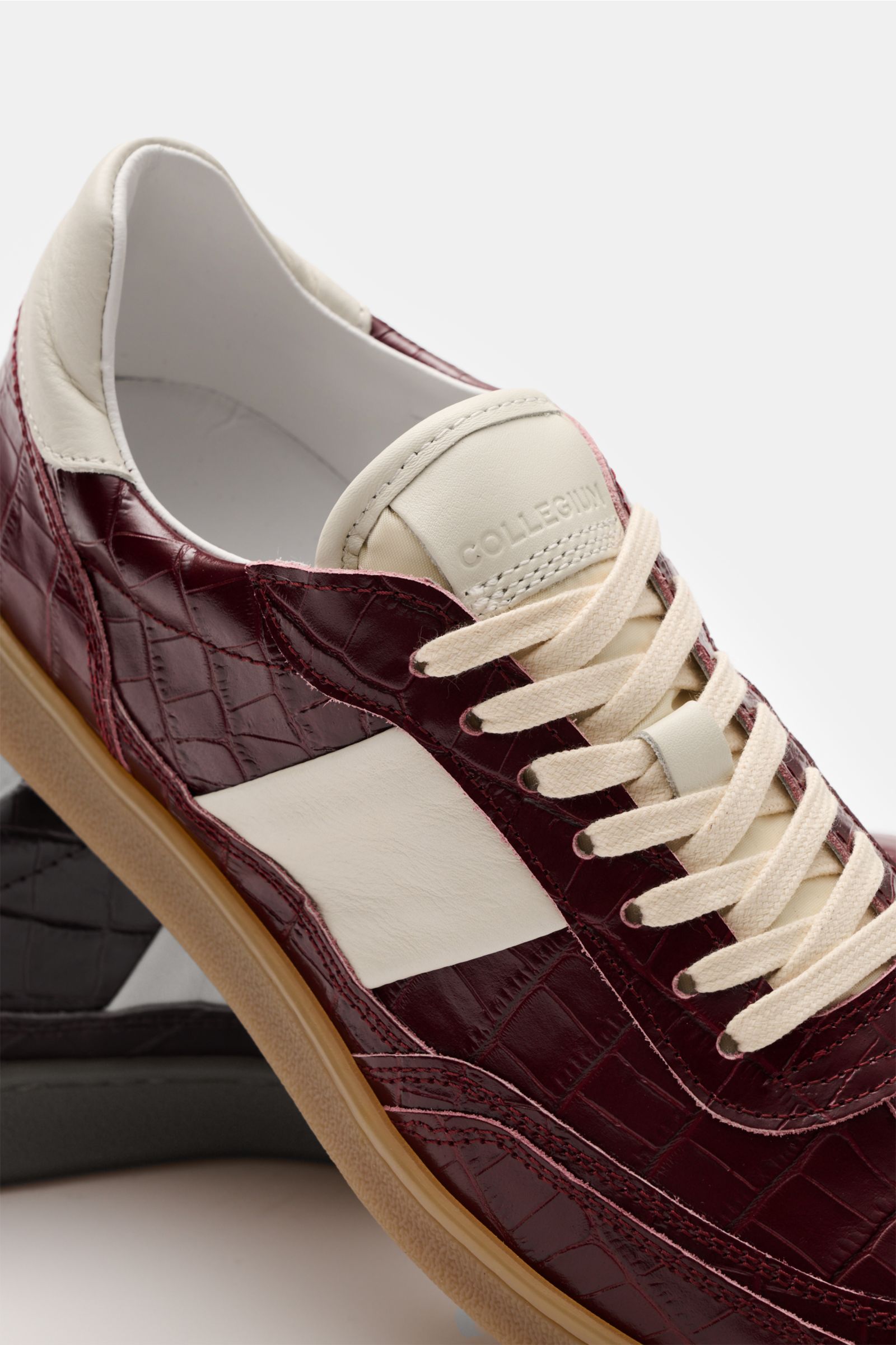 Collegium Sneaker 'Pillar Court II' bordeaux aus reptiloptischem Kalbsleder, seitlich schräg, mit runder Vorderkappe, sieben-Loch-Schnürung, Logo-Lasche, gepolstertem Schaftrand, Leder-Innenfutter und flexibler Gummisohle.