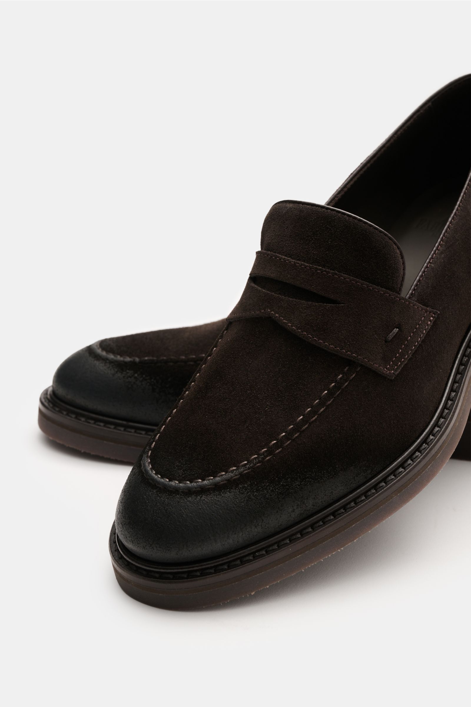 Close-up front-side view of Fabiano Ricci Penny Loafer dunkelbraun in dark brown velour leather with a penny strap and waxed toe and heel.

Description: Klassik mit Charakter: Dieser Penny Loafer aus Veloursleder verbindet traditionelle Form mit subtil