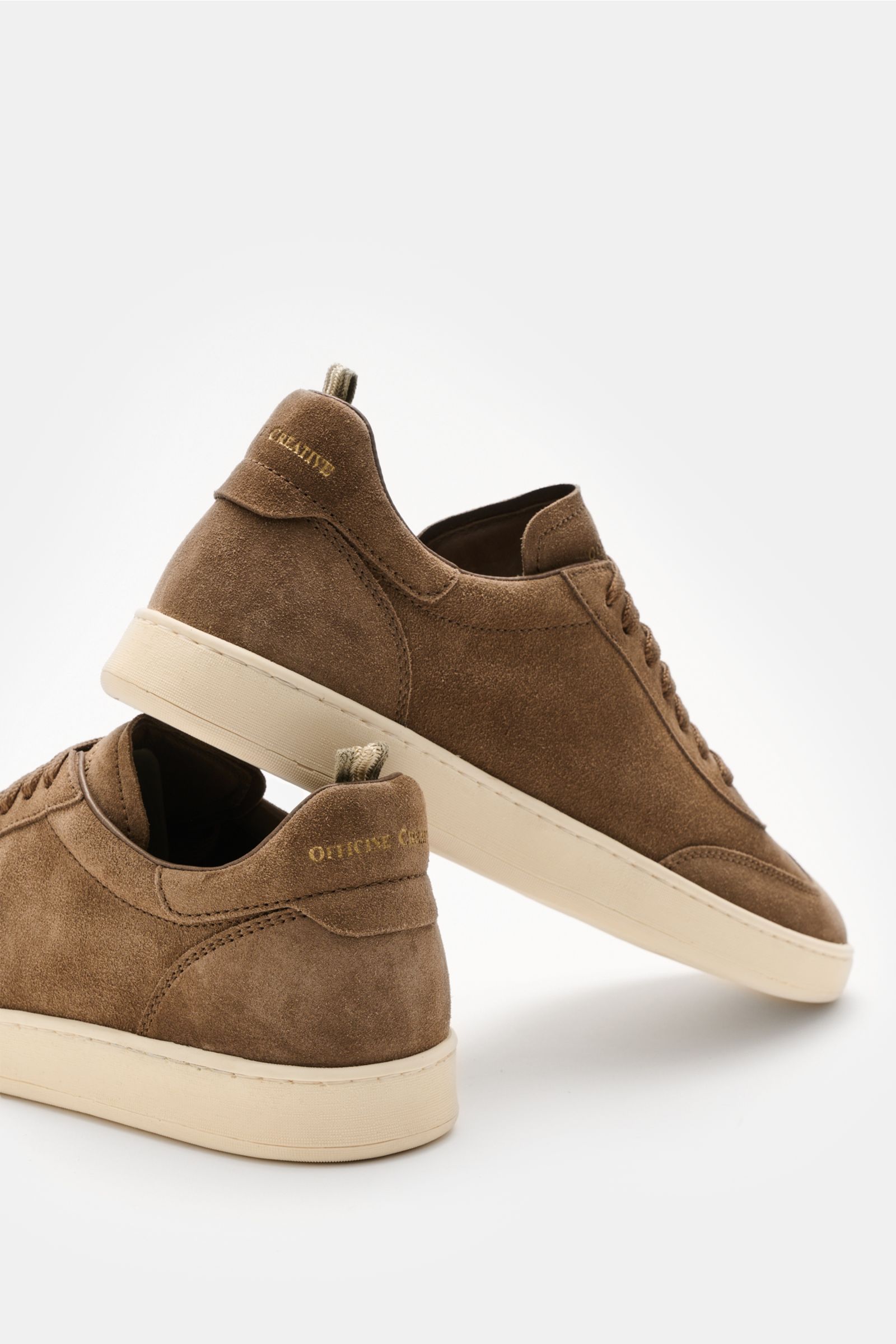 Side and rear view of Officine Creative Sneakers 'Kafka' taupe in premium suede with round toe cap, wing cap, embossed logo on tongue and heel, high padded topline, leather lining, and lightweight rubber sole.

For anyone who appreciates comfort: The s