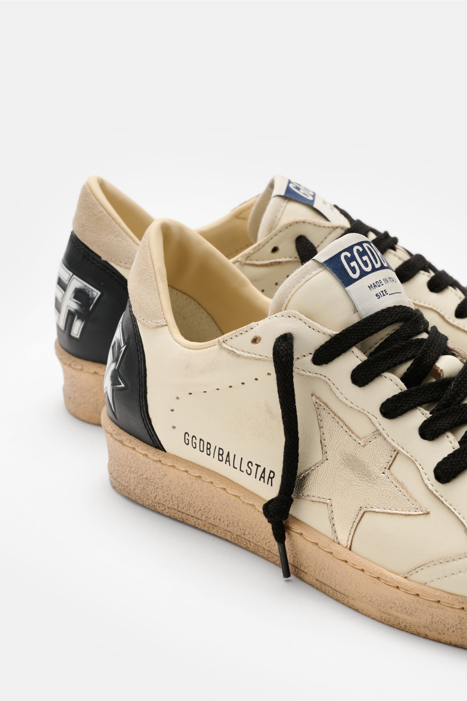 Golden Goose Sneaker 'Ball Star' offwhite/schwarz/silber, seitliche Nahaufnahme, Vintage-Finish, handgemachte Used-Optik, Stern, Nappaleder, Veloursleder, gepolsterter Schaftrand, perforierte Vorderkappe, flexible Gummisohle in Used-Optik.