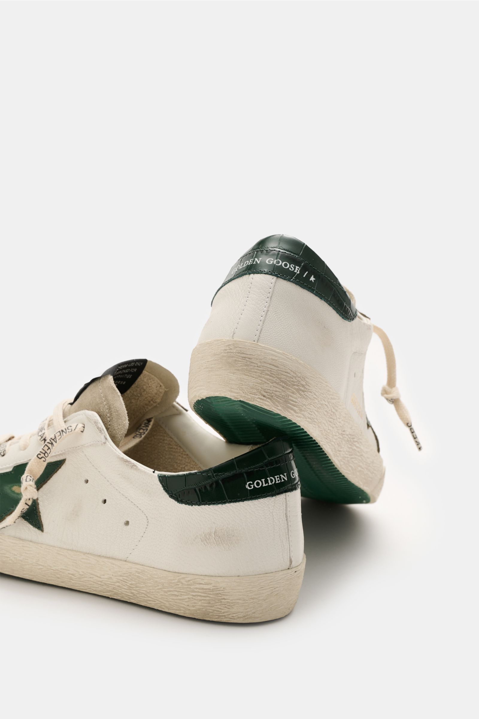 Golden Goose Sneaker 'Super-Star Classic' offwhite/dunkelgrün, Vintage-Finish, Ledersohle, Stern-Detail, schräg von hinten fotografiert, Used-Look.