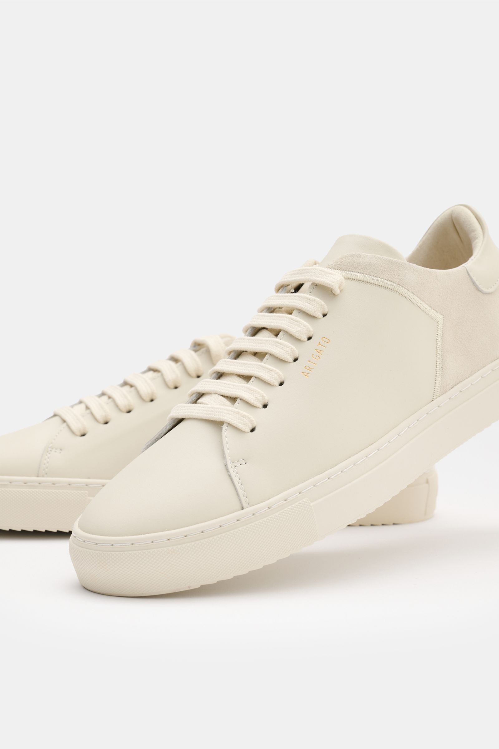 Axel Arigato Sneaker 'Clean 90 Split' creme, Seitenansicht, minimalistischer Sneaker aus Glatt- und Veloursleder mit runder Vorderkappe, sieben-Loch-Schnürung, goldfarbener Prägung, gepolstertem Schaftrand und flexibler Gummisohle.