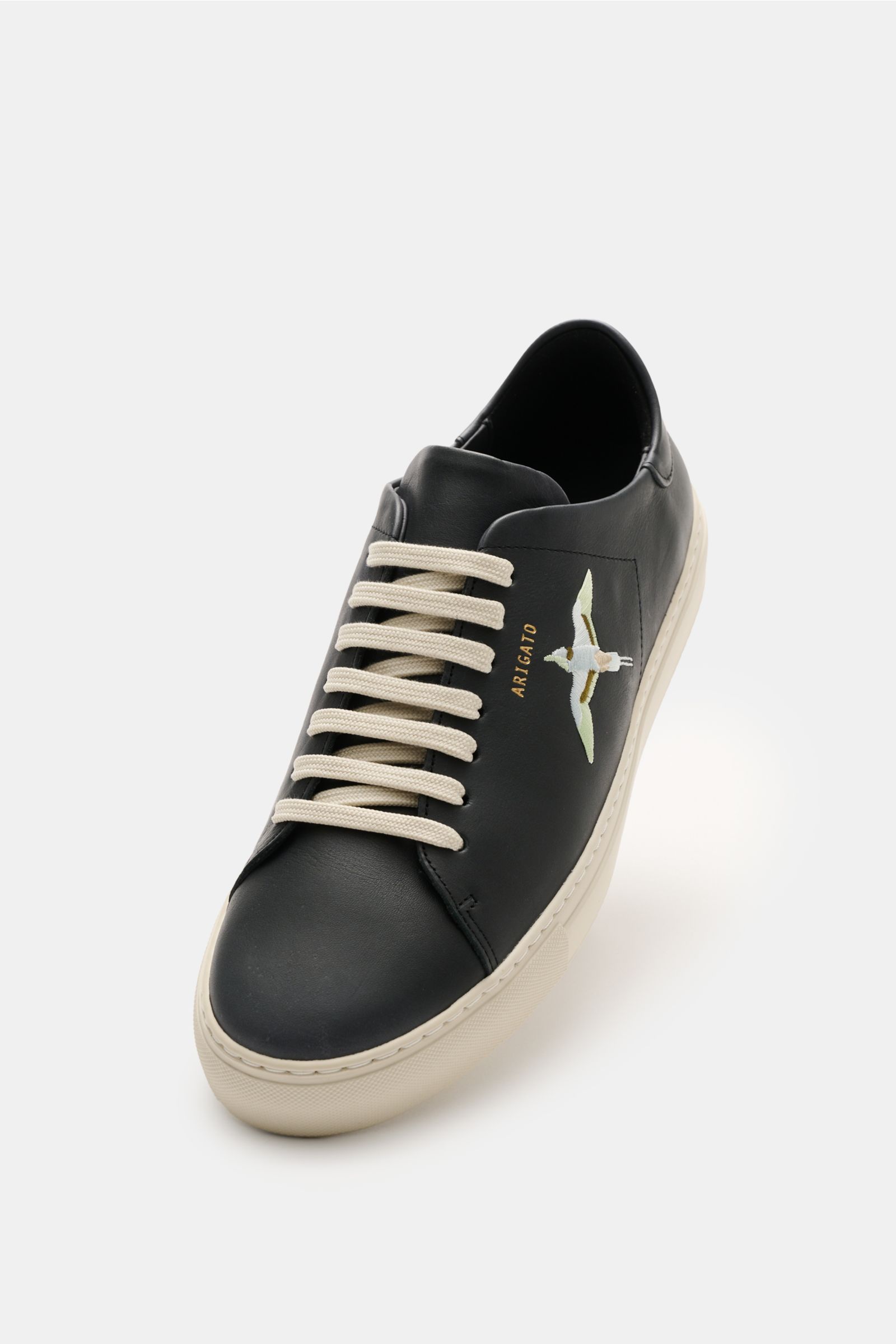 Axel Arigato Sneaker 'Clean 90 Bee Bird' schwarz/weiß, seitlich vorne fotografiert, Glattleder, Bee Bird Stickerei, goldene Prägung, weiße Sohle, gepolstert.