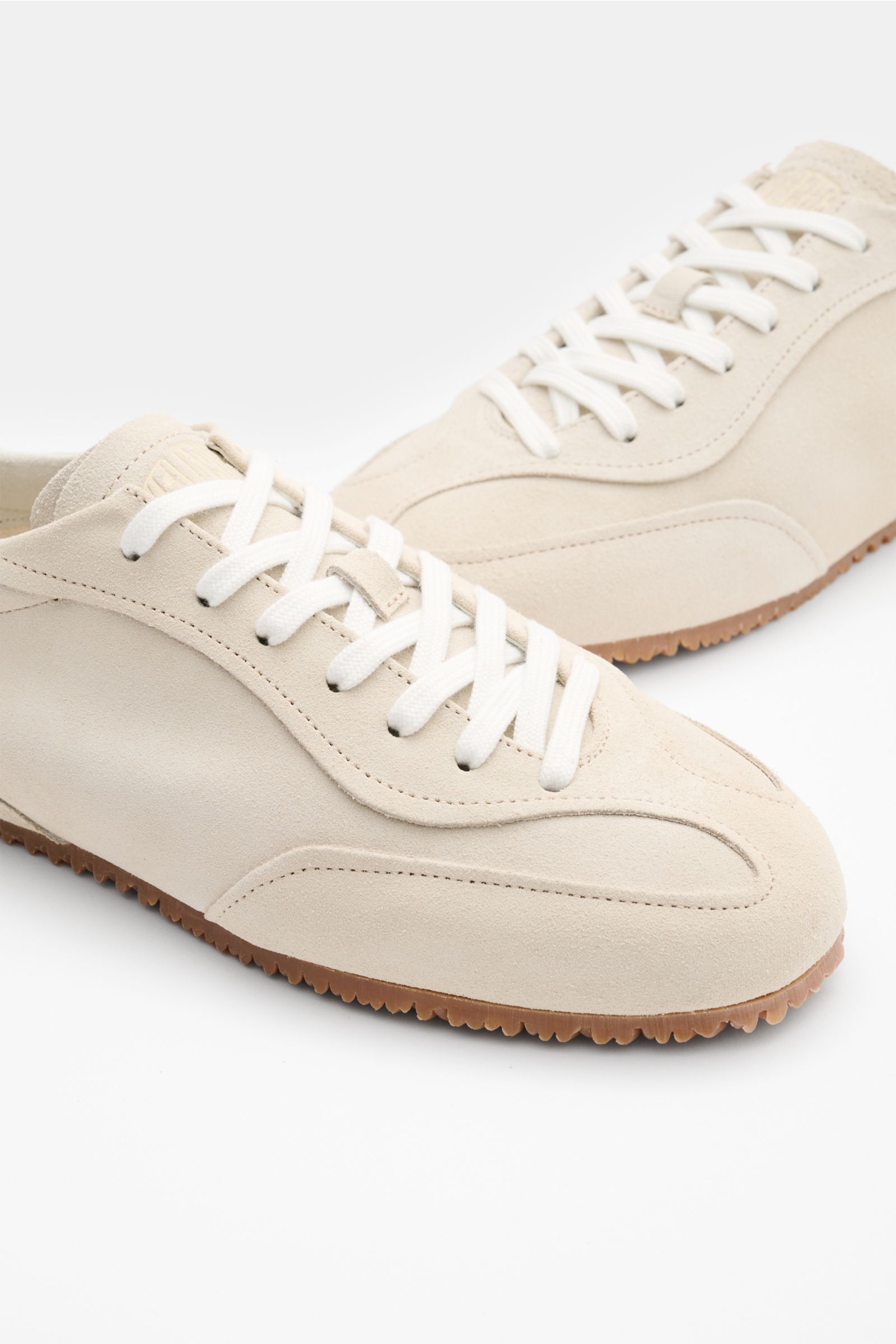 Axel Arigato Sneaker 'Daze Runner' beige aus Veloursleder mit runder Vorderkappe, Sieben-Loch-Schnürung, gepolstertem Schaftrand, Frottee-Innenfutter, flexibler Gummisohle, seitliche Perspektive.