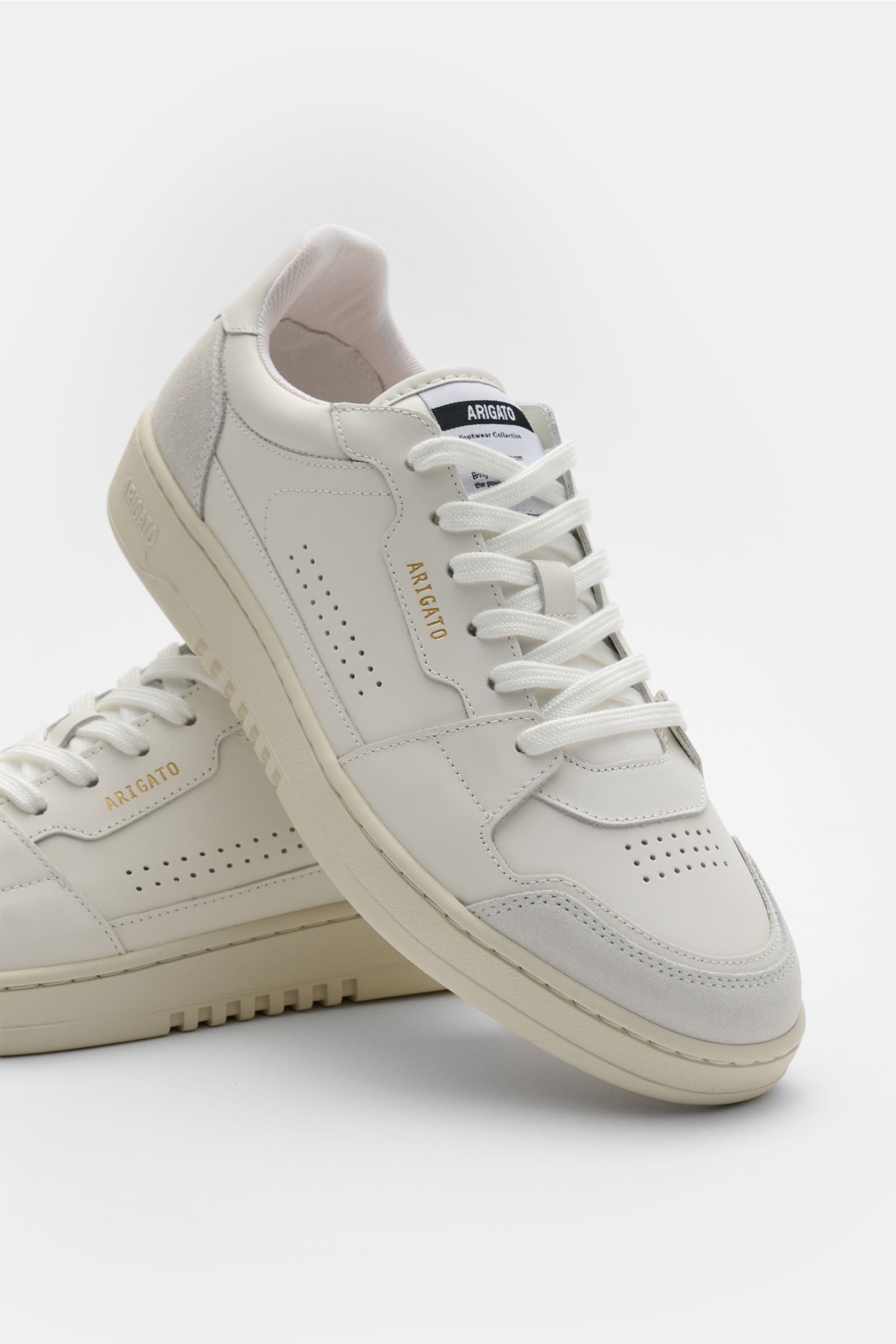 Axel Arigato Sneaker 'Dice Lo' weiß, seitliche Frontansicht, Alltags-Sneaker aus Glattleder mit Nubuk-Overlays, perforierter runder Vorderkappe, sechs Loch Schnürung, goldfarbener Label-Prägung, gepolstertem Schaftrand und flexiblem Gummi-Sohle.