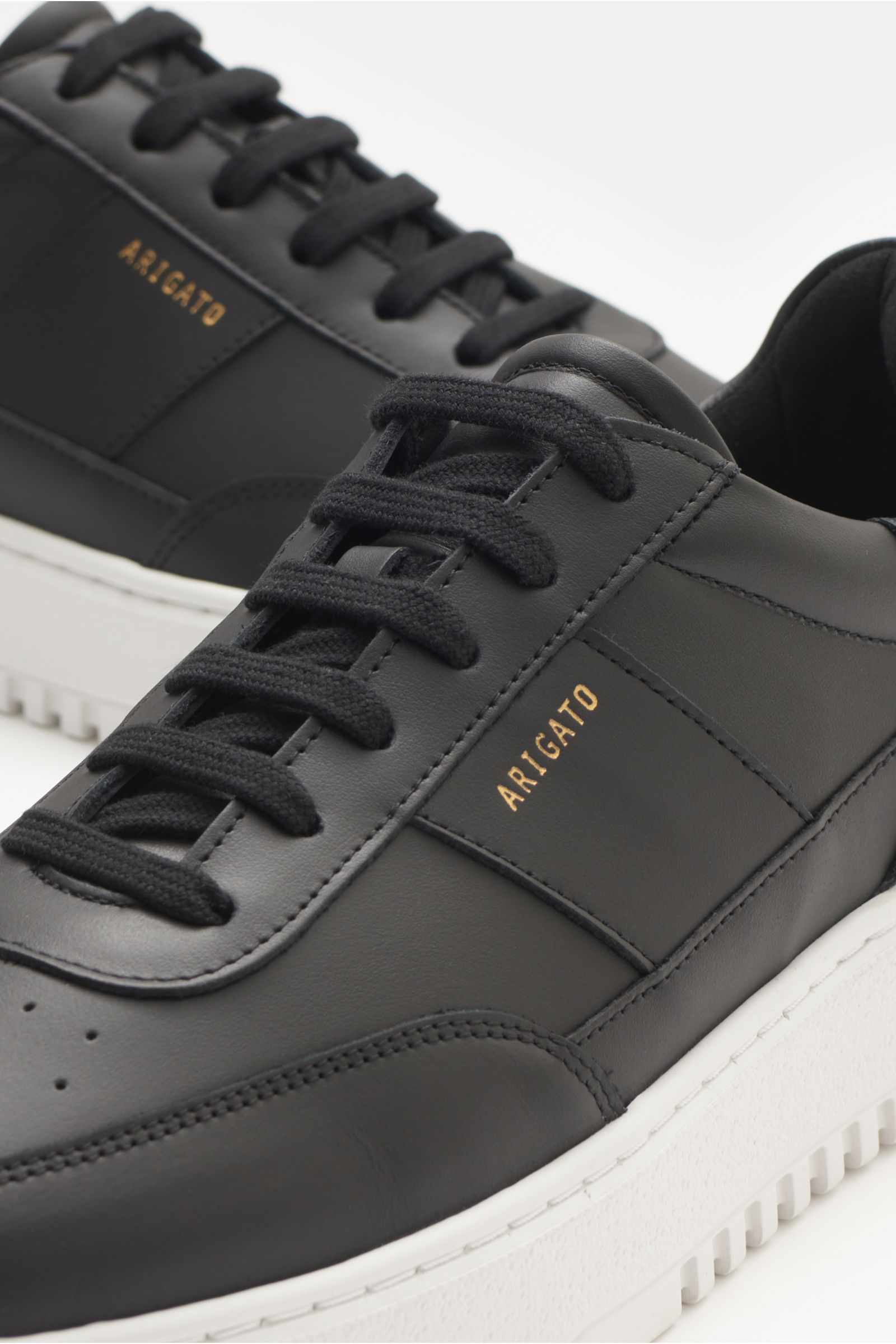 Axel Arigato Sneaker 'Orbit Vintage' schwarz, Detailansicht von oben schräg, Glattleder, tonale Overlays, goldfarbene Prägung, gepolsterter Schaftrand, flexible weiße Gummisohle.