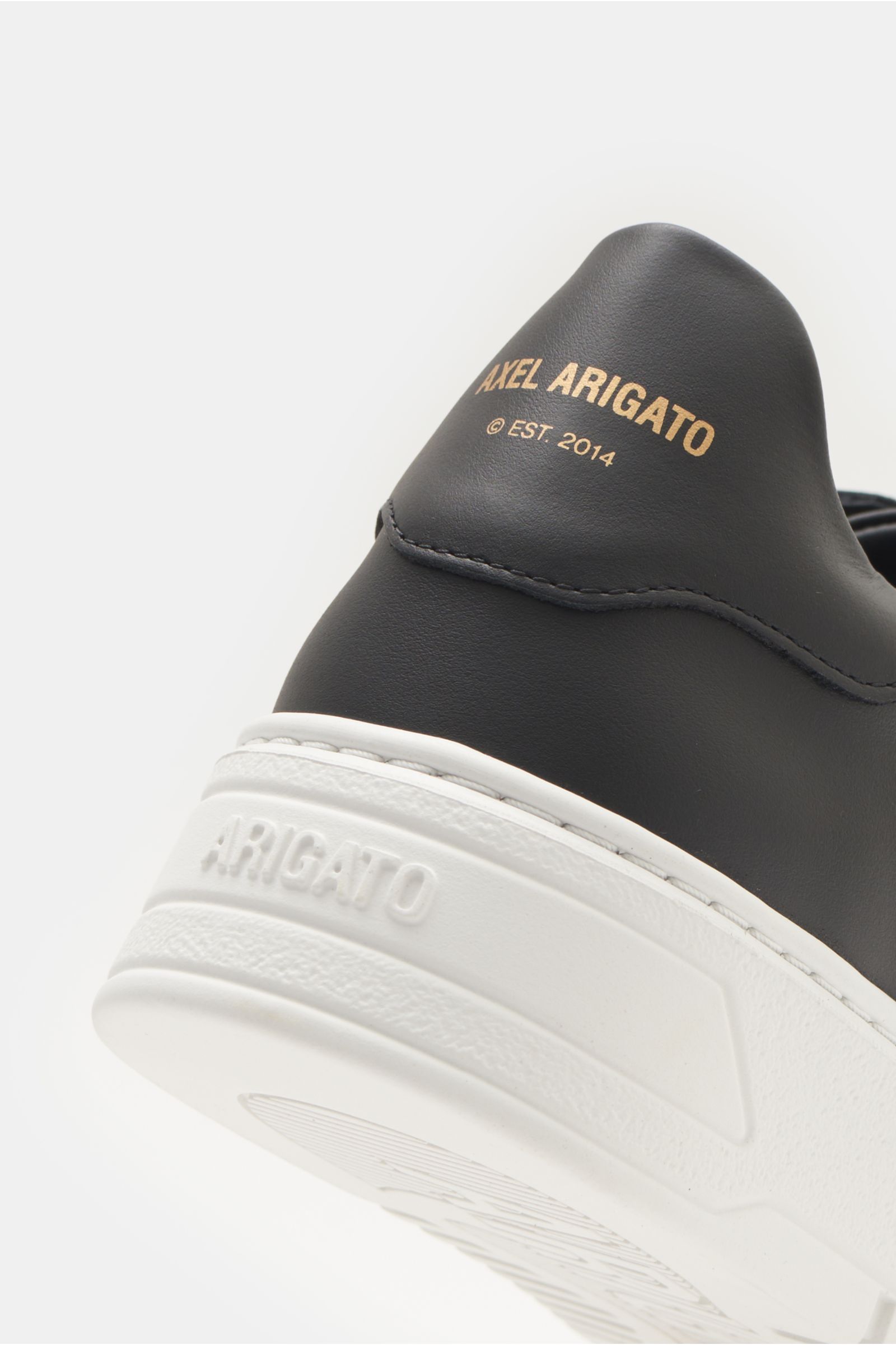 Axel Arigato Sneaker 'Orbit Vintage' schwarz, Detailaufnahme von hinten oben, Glattleder, goldfarbene Prägung, weiße genähte Gummisohle.