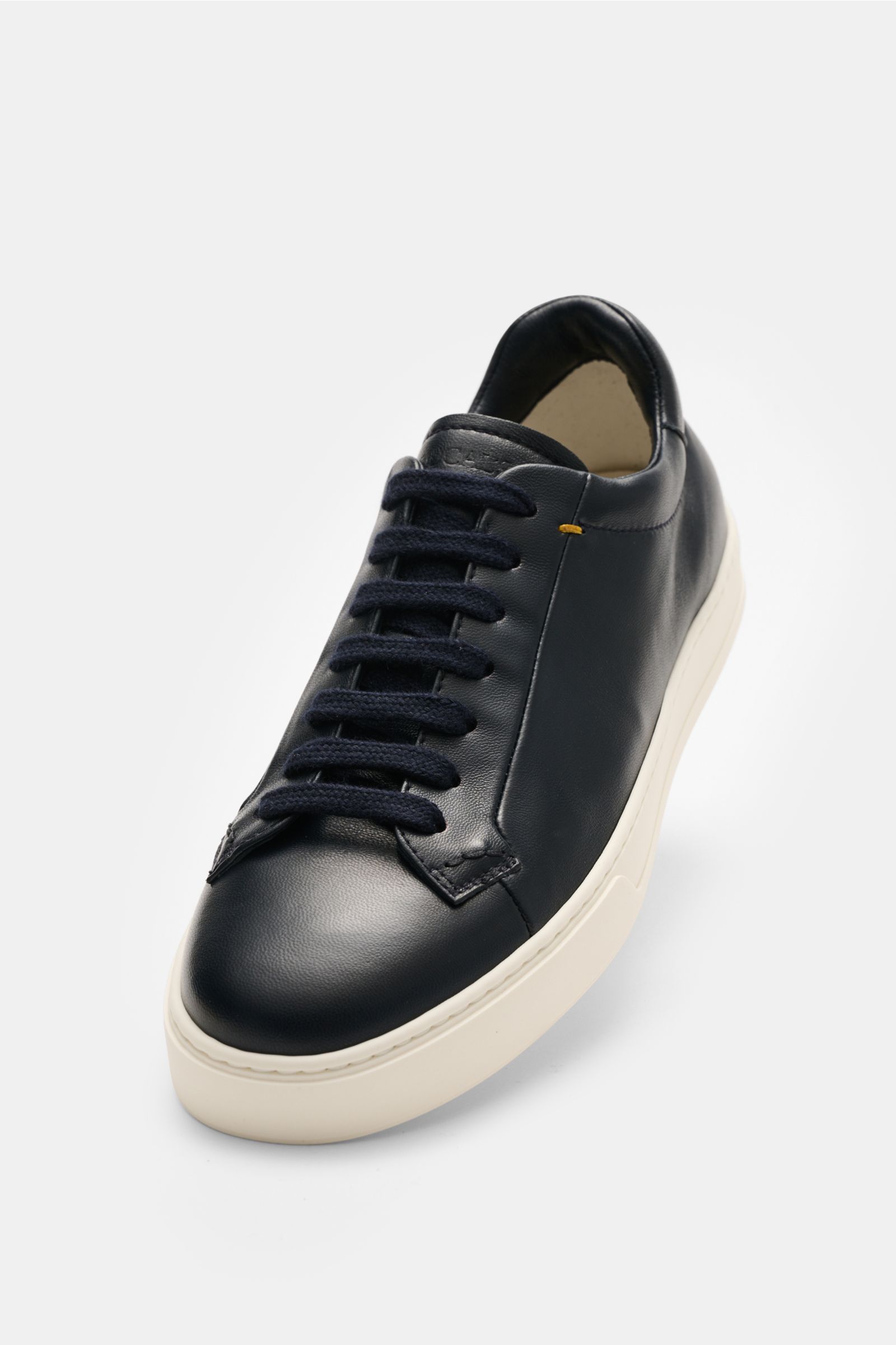 Front angled view of Doucal's Sneakers 'Plonge' dark navy low top sneaker with premium smooth leather, seven-eyelet lacing, padded topline, leather lining, and flexible rubber sole. Timeless sneakers essential: The low top sneakers 'Plonge' by DOUCAL'S ar