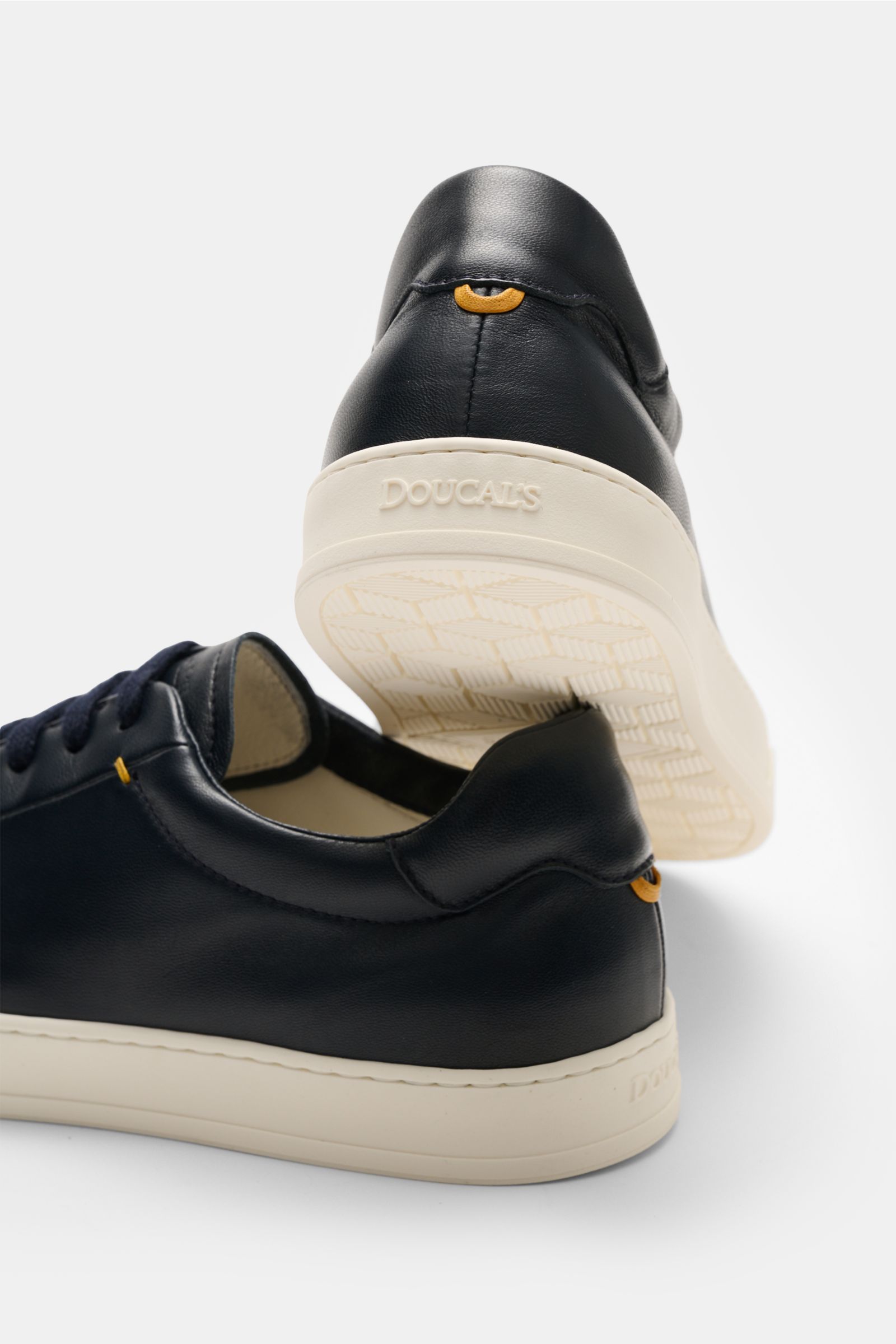 Close-up rear and side view of Doucal's Sneakers 'Plonge' dark navy, showcasing premium smooth leather, seven-eyelet lacing, padded topline, leather lining, and flexible rubber sole. Timeless sneakers essential: The low top sneakers 'Plonge' by DOUCAL'S a