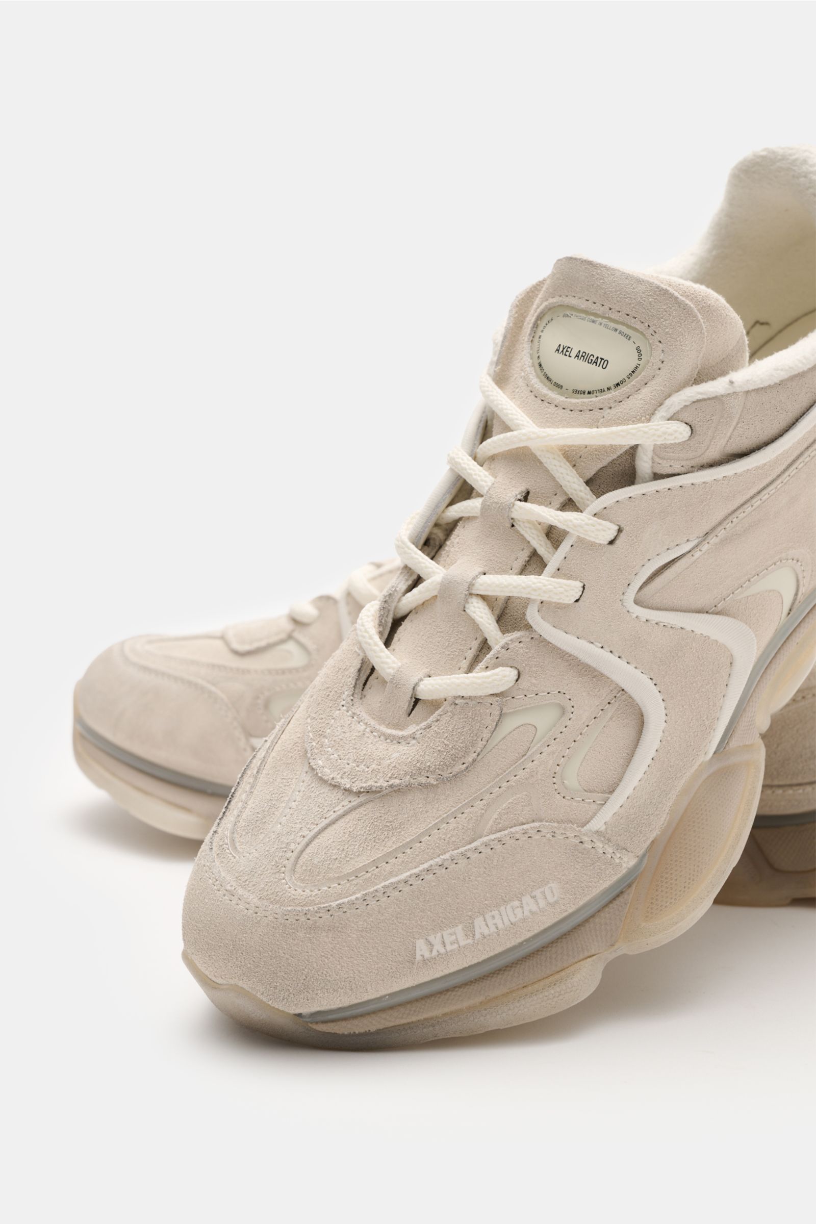 Axel Arigato Sneaker 'Eris' offwhite shown from front side, made of noble suede leather with overlays of smooth and suede leather, narrow silhouette, four-hole lacing, logo patch on tongue, textile lining, and rubber outsole; for trendy spring styles.