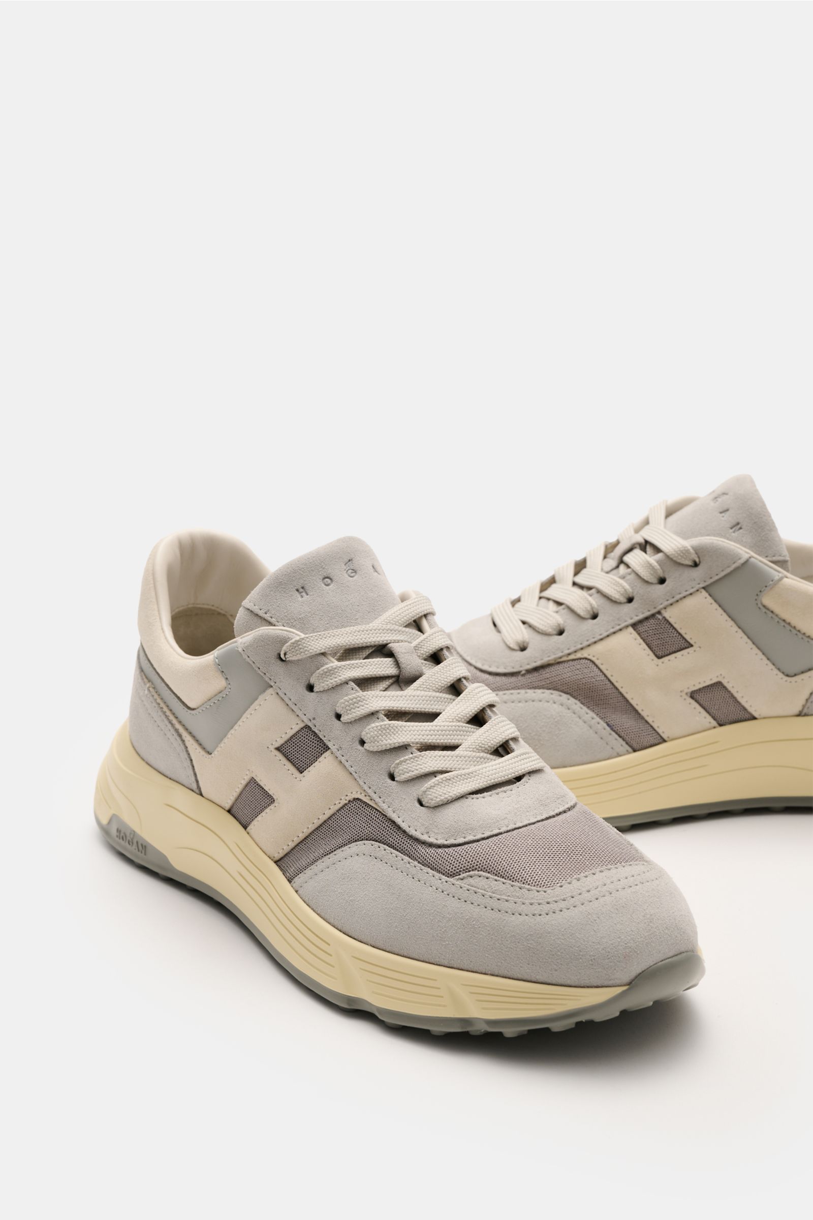 Hogan Sneaker 'Hyperlight' grau/beige, seitlich-vorne fotografiert, aus Veloursleder mit Memory-Foam-Sohle, gepolstertem Schaftrand, 6-Loch-Schnürung, Leder/Textilfutter und Gummisohle mit Stollen-Profil.