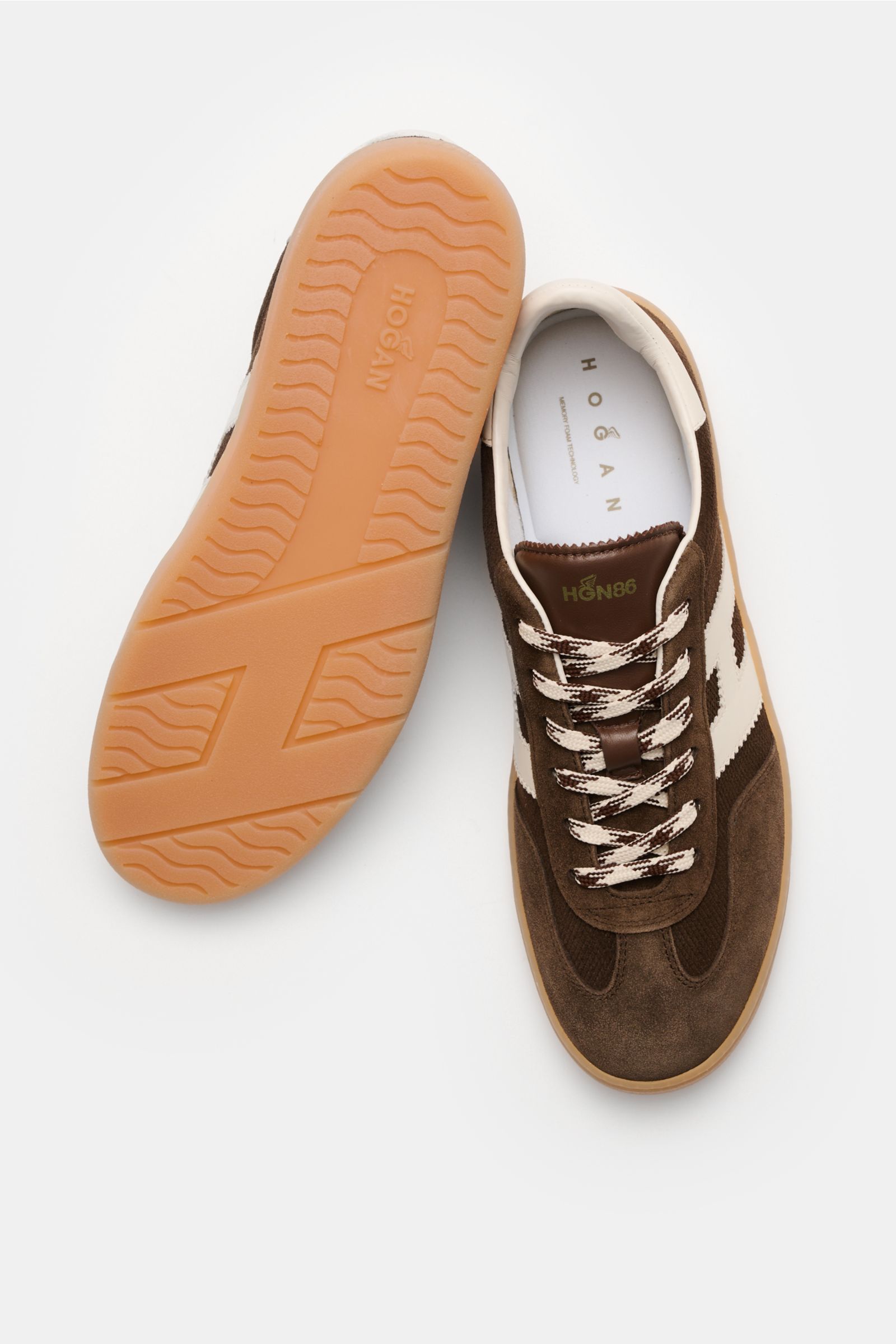 Hogan Sneaker 'Allacciato' dunkelbraun/weiß shown from top and sole view, made of embossed suede, six-hole lacing, logo print tongue, padded collar, H-shaped brand initial, leather/textile lining, memory foam insole, and flexible rubber sole.