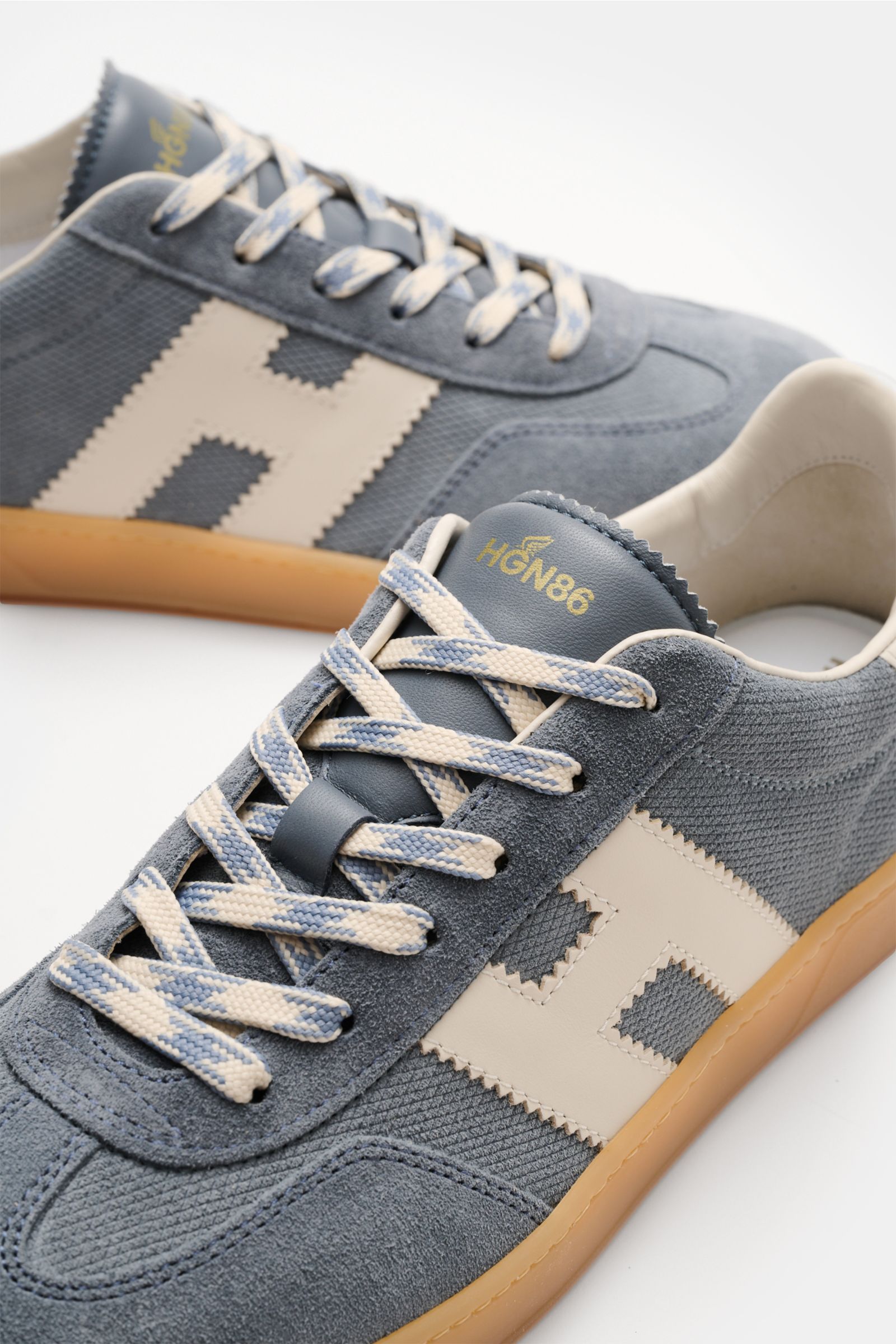 Hogan Sneaker 'Allacciato' rauchblau/weiß shown from a close-up side angle, featuring embossed suede, six-hole lacing, logo-printed tongue, padded collar, H-shaped brand initial, leather and textile lining, memory foam footbed, and flexible rubber sole. 