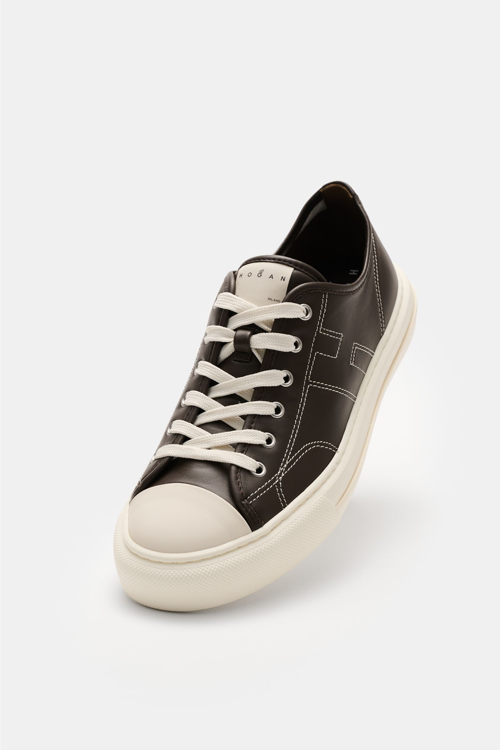 Front angled view of Hogan Sneaker 'Allacciato Cuciture' dunkelbraun/offwhite in smooth dark brown leather with off-white toe cap and sole, featuring seven-hole lacing, logo-printed tongue, H-shaped brand initial, leather and textile lining, memory foam f