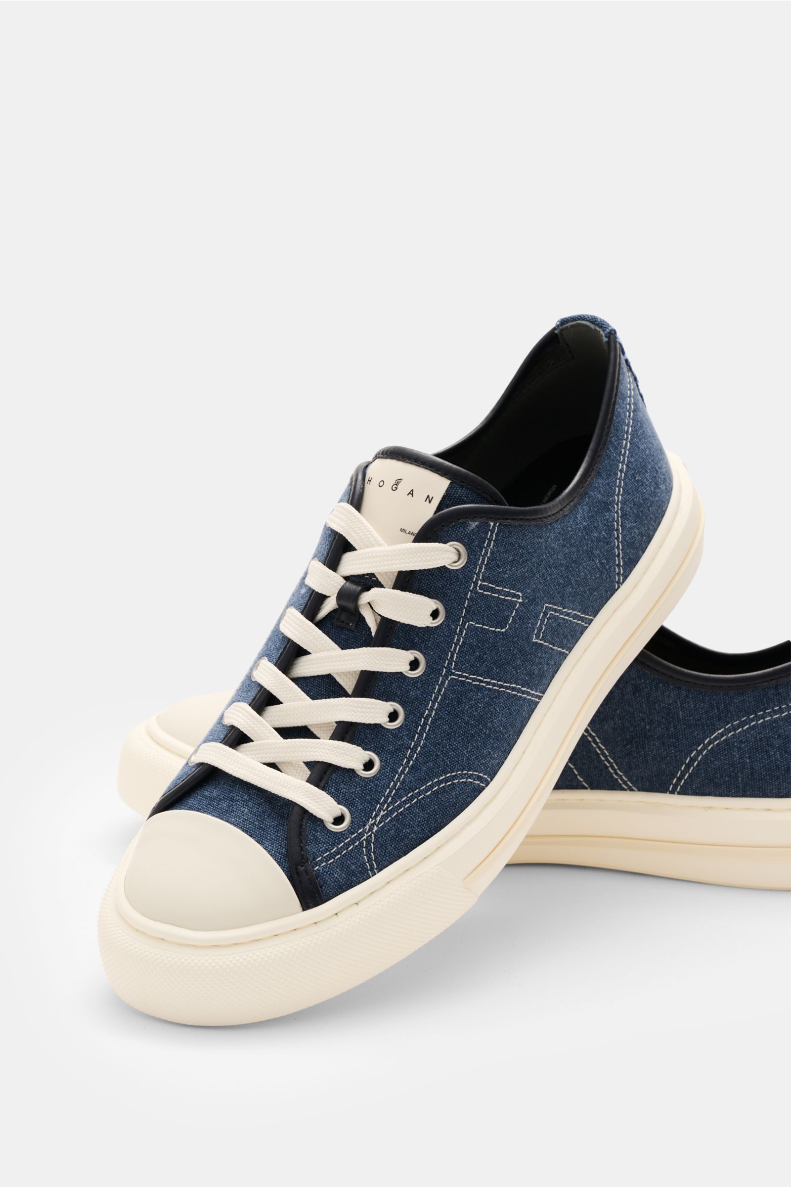 Hogan Sneaker 'Allacciato Cuciture' dunkelblau/offwhite aus robustem Canvas mit Memory-Foam-Fußbett, Sechs-Loch-Schnürung, Logo-Print, H-Initial, flexible Gummisohle, von schräg vorne fotografiert.