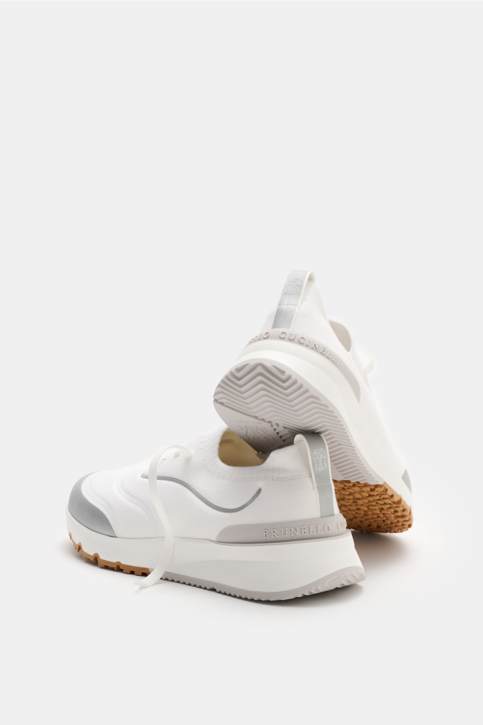Brunello Cucinelli Sneaker weiß/silbergrau shown from a rear-side angle, featuring a knitted exterior, slim shape, three-eyelet lacing, rubber details, textile lining, and durable rubber sole; perfect for the urban man with comfort for city strolls.