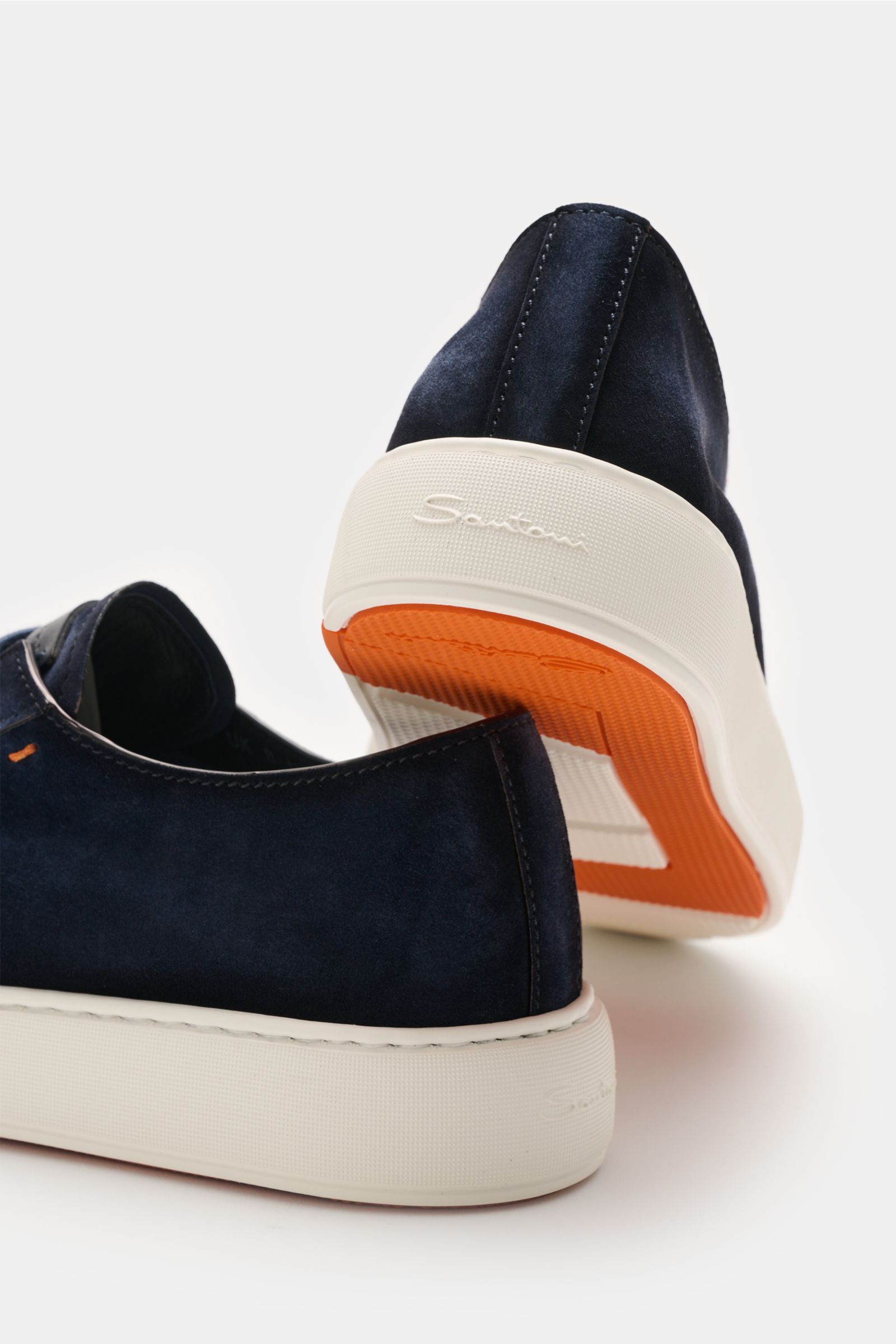 Rear and side view of Santoni Sneaker 'Clean Icon' navy in fine navy velour leather with white rubber sole and orange outsole detail.

Description: Ein Klassiker für den Casual Friday: Mit dem Sneaker 'Clean Icon' von SANTONI aus feinem Veloursleder un