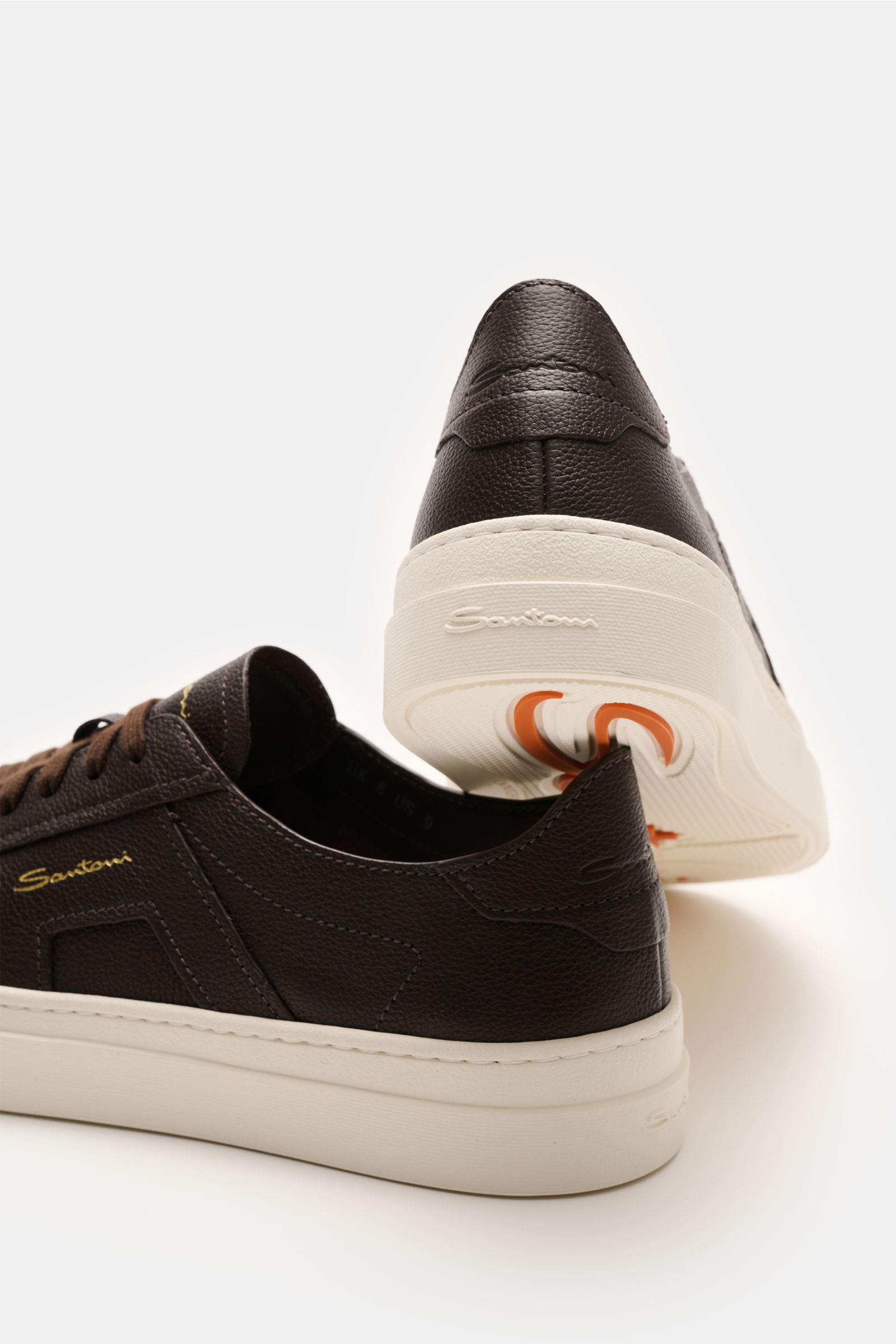 Santoni Sneaker 'Double Buckle' dunkelbraun shown from rear and side angles, made of finely grained leather with white sole. Hommage an einen Klassiker: Die Overlays auf den Seiten dieser Sneaker von SANTONI aus edlem, fein genarbtem Leder sollen an die S