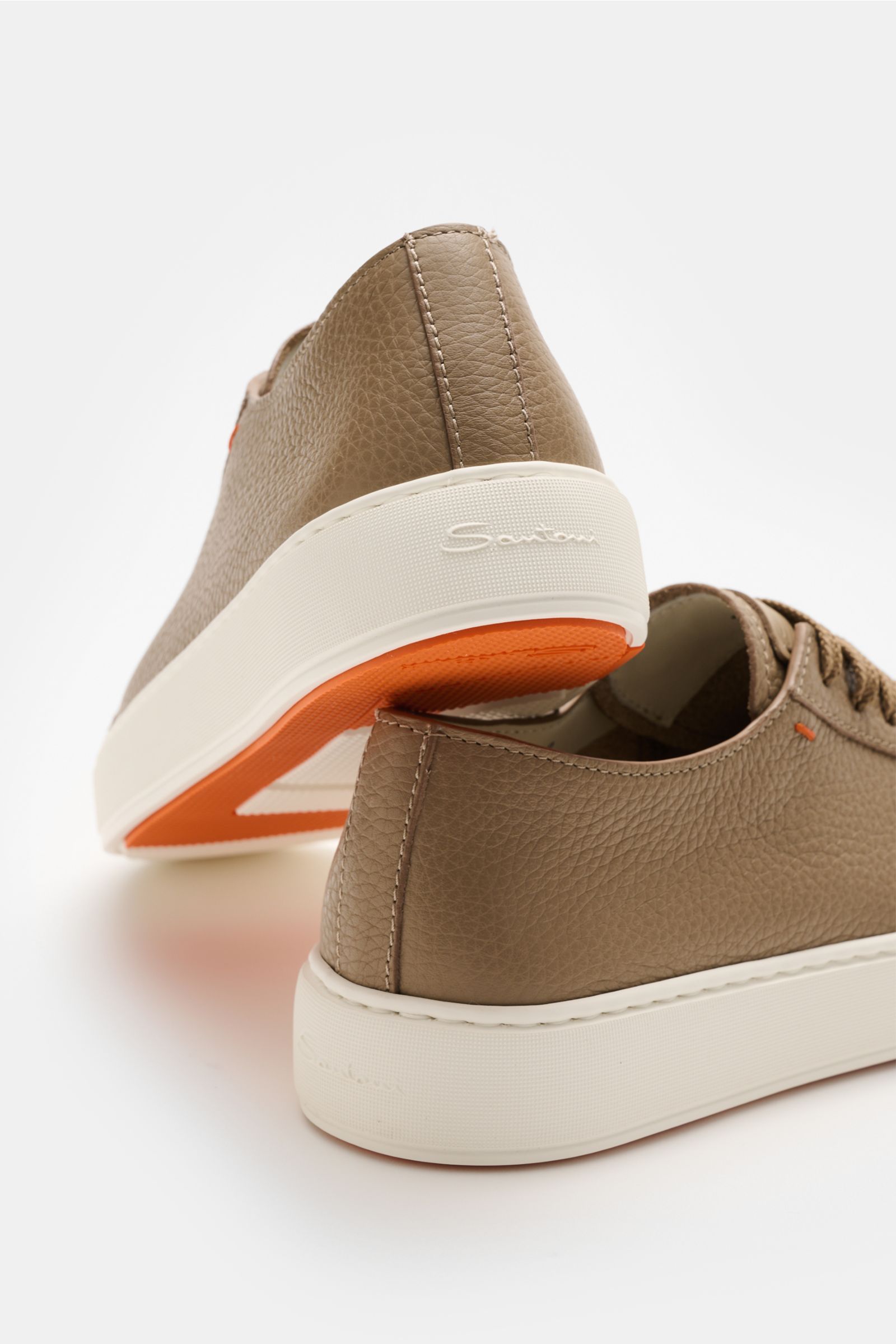Rear and side view of Santoni Sneaker 'Clean Icon' taupe, featuring markant genarbtes Glattleder, matte Optik, runde Vorderkappe, Sieben-Loch-Schnürung, dezentes kontrastfarbiges Stitching-Detail, Innenfutter aus Leder, and flexible Kautschuksohle with or