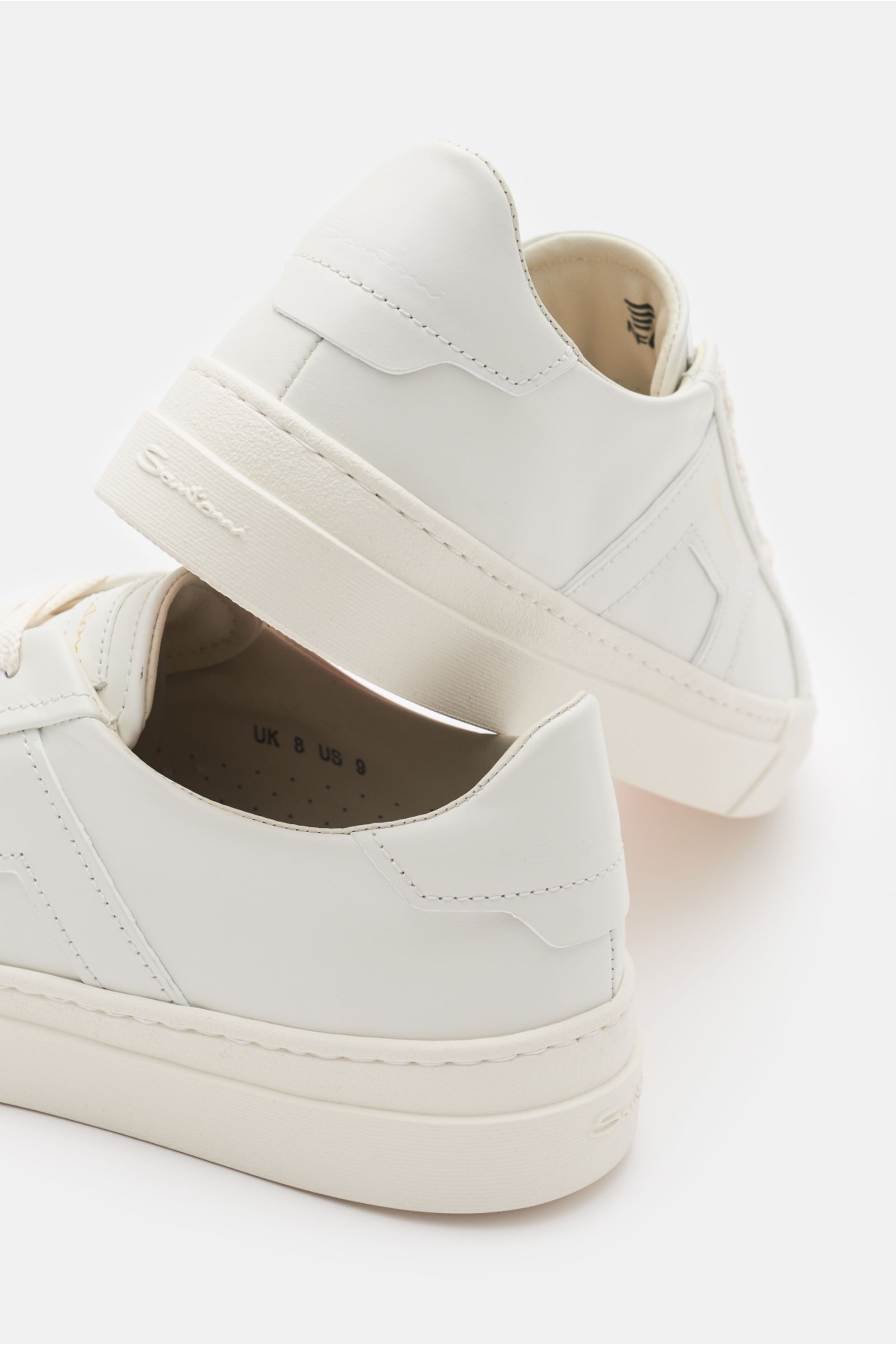 Santoni Sneaker 'Double Buckle' weiß shown from a rear-side angle, crafted from edles Glattleder with sieben-Loch-Schnürung, runde Vorderkappe, tonale Overlays, tonales Emblem, gepolsterter Schaftrand, Innenfutter aus Leder, flexible Kautschuksohle, and S