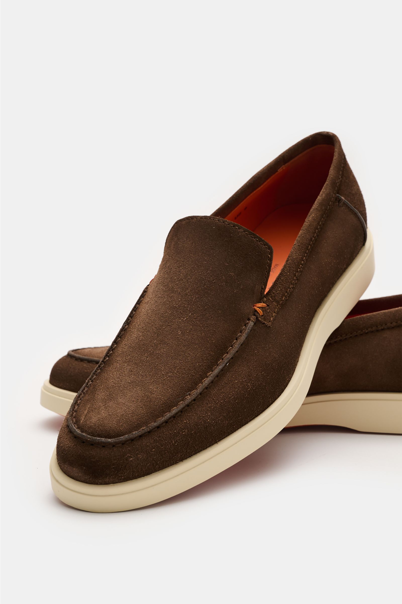 Brauner Santoni Loafer 'Detroit' aus geschmeidigem Veloursleder mit schmaler Silhouette, Ziernaht und heller Kautschuksohle, frontale Nahaufnahme.