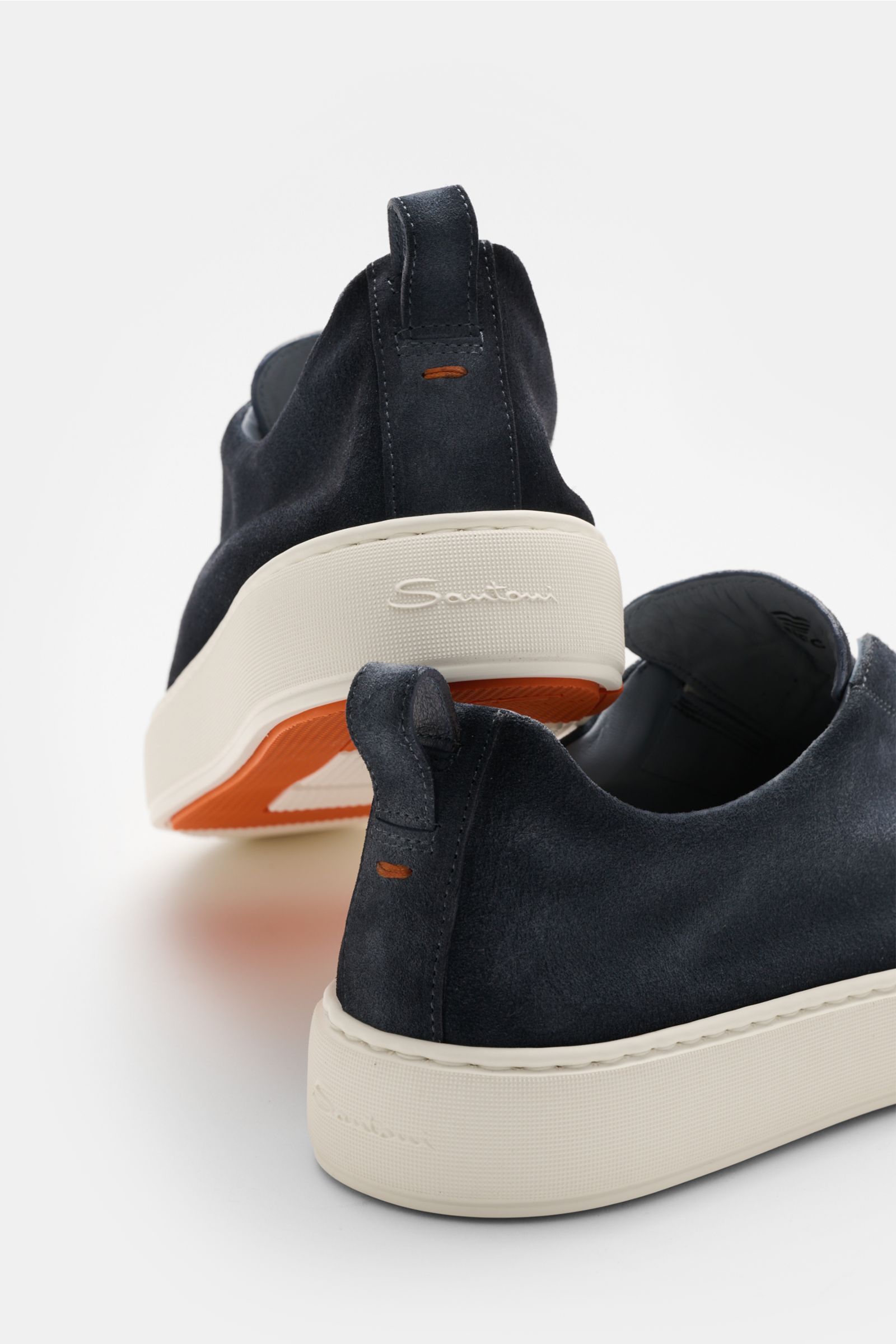 Santoni Slip-on-Sneaker 'Victory' graublau shown from the rear and side, made of smooth grey-blue velour leather, slim tapered, with elastic pull tab, subtle logo embossing, practical loop, leather lining, and lightweight white rubber sole ensuring comfor