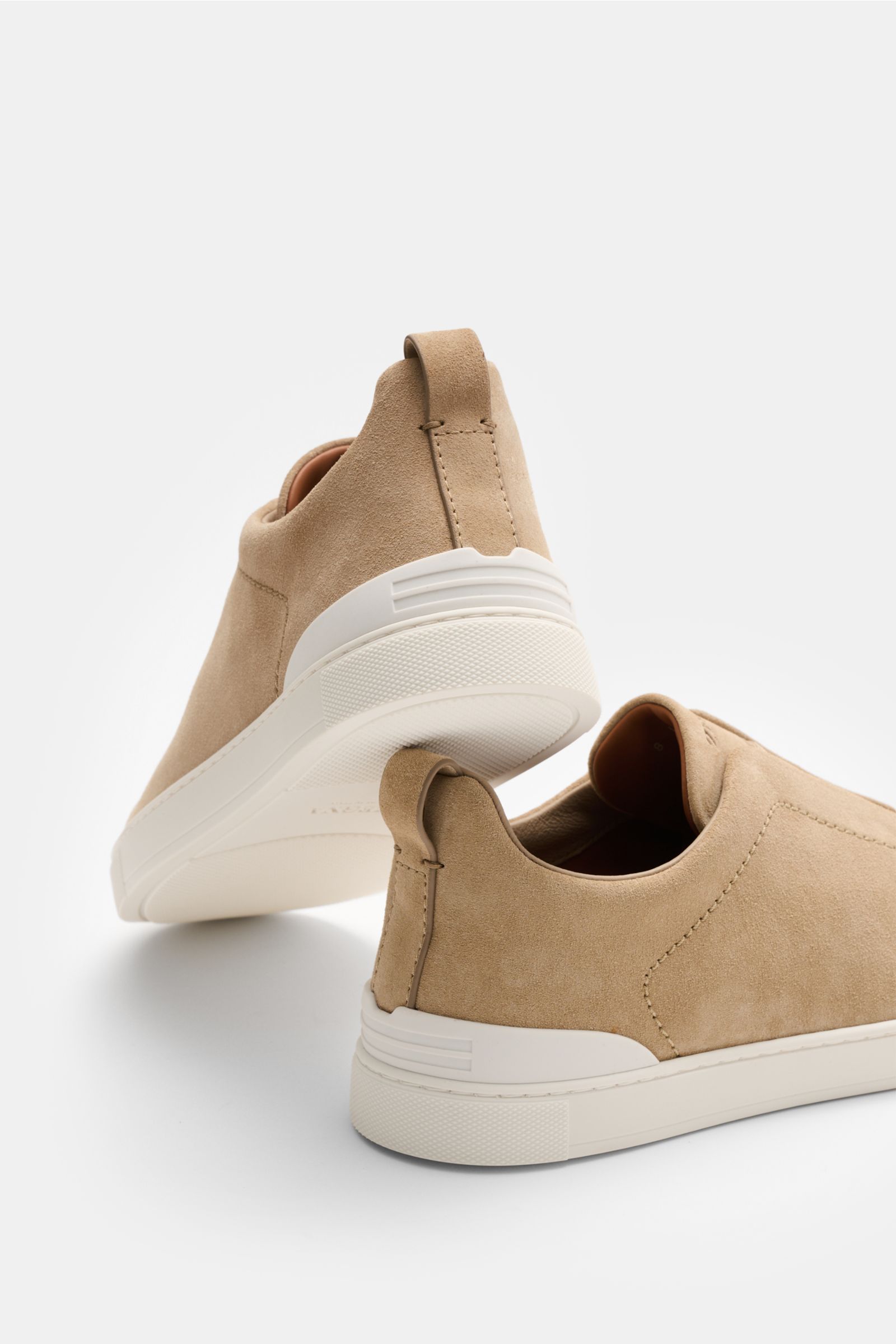 Rear and side view of Zegna Slip-on sneakers 'Triple Stitch' sand in smooth suede, featuring round toe, elastic straps, padded topline, pull loop, ZEGNA embossing, leather lining, and flexible rubber sole.