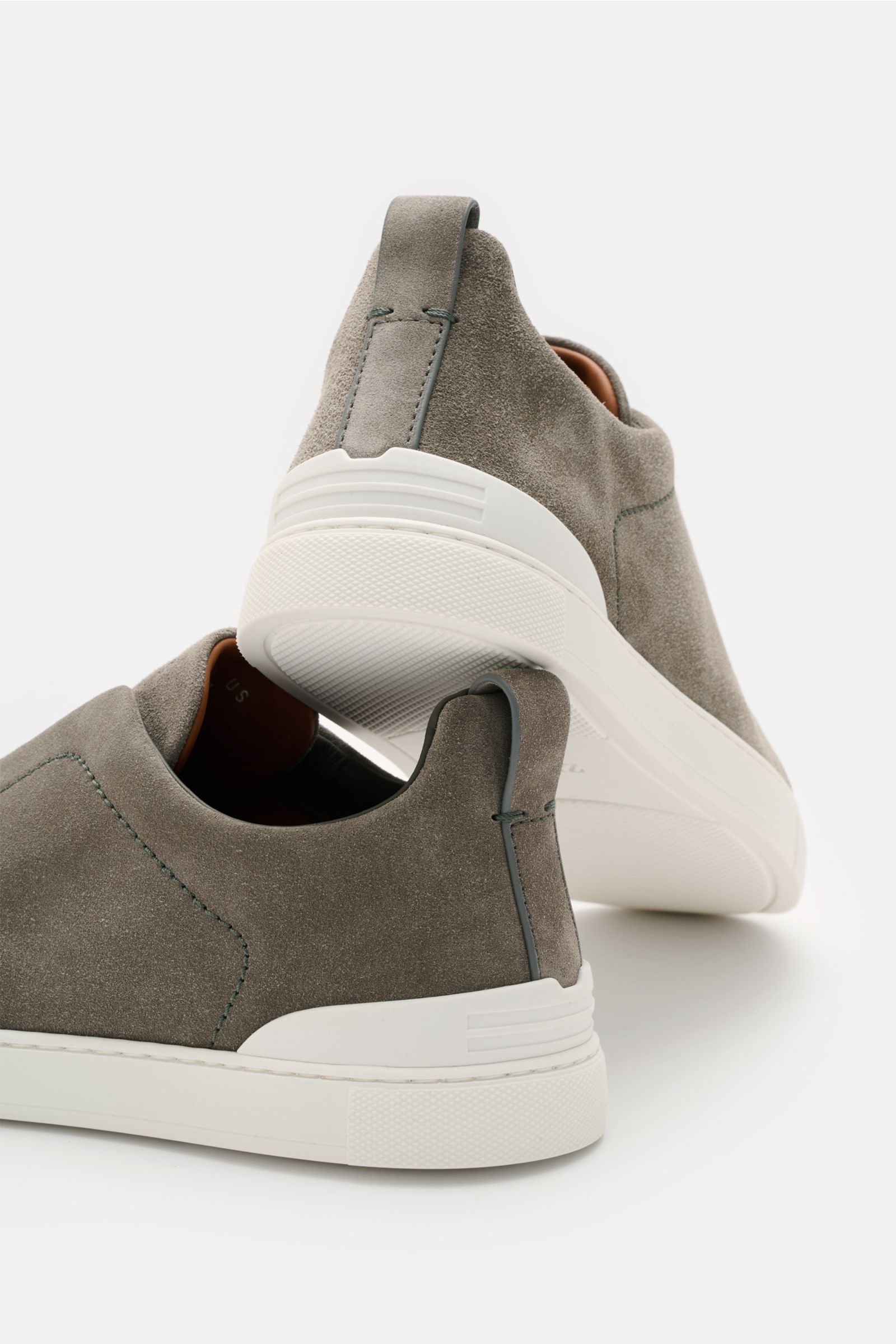 Zegna Slip-on-Sneaker 'Triple Stitch' grau, aus geschmeidigem Veloursleder, seitlich und von hinten fotografiert, mit elastischen Bändern und weißer Gummisohle.