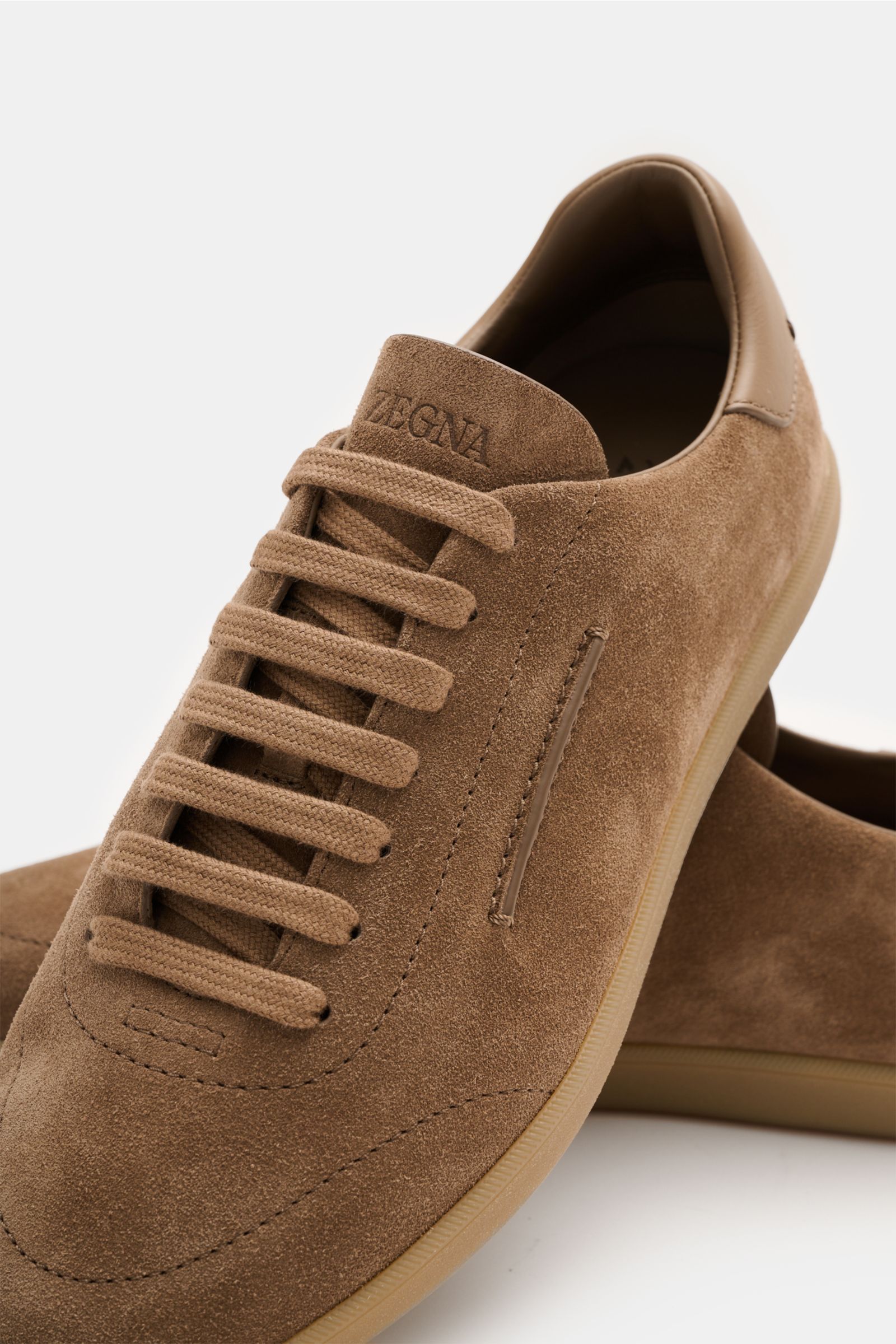 Zegna Sneaker braun aus Veloursleder mit runder Vorderkappe, sieben-Loch-Schnürung, ZEGNA-Prägung, Lederfutter, flexible Sohle, Detailansicht.