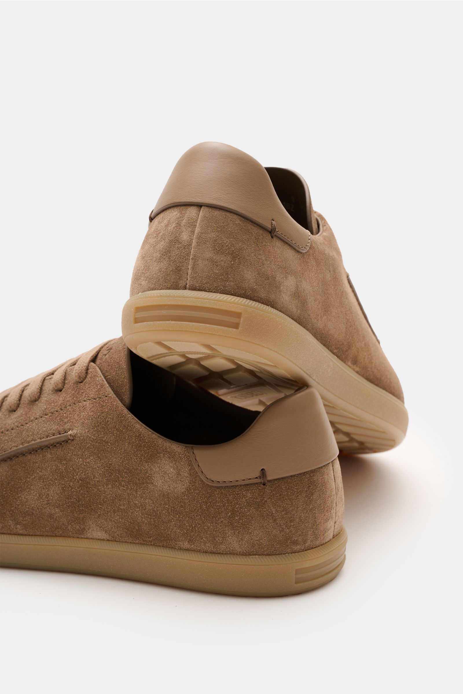Zwei Zegna Sneaker braun aus geschmeidigem Veloursleder mit runder Vorderkappe, Sieben-Loch-Schnürung, Lederinnenfutter, ZEGNA-Prägung, flexible Kautschuksohle, von schräg hinten fotografiert.