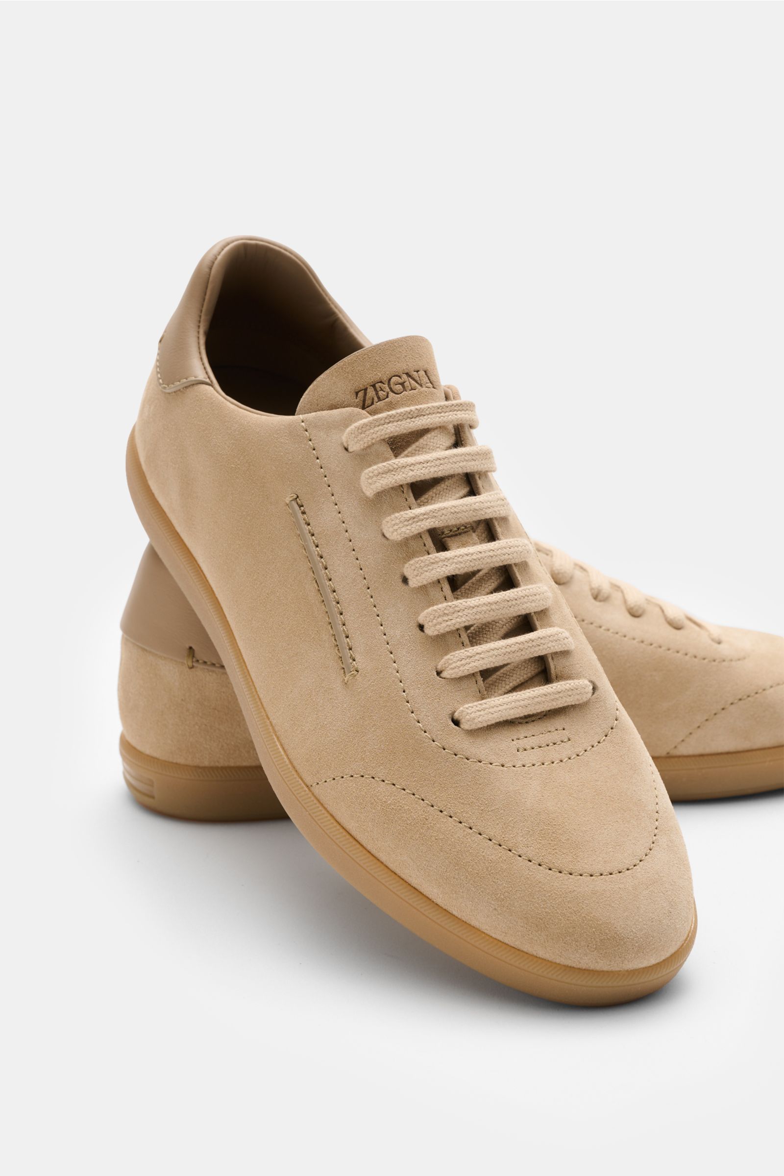 Front angled view of Zegna Sneakers sand in smooth suede with round toe, seven-eyelet lacing, embossed tongue, leather lining, and flexible rubber sole.
