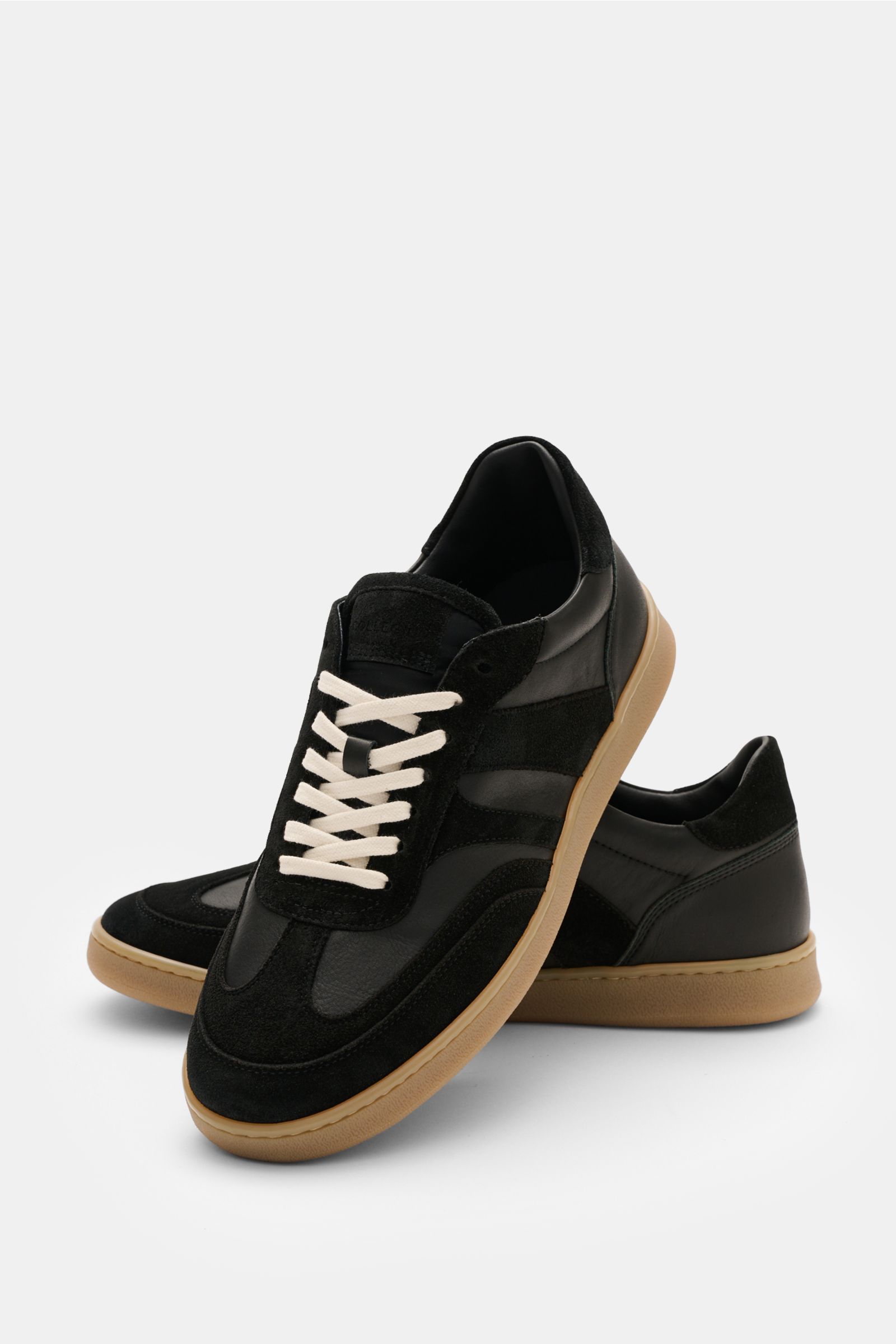 Collegium Sneaker 'Pillar Court III' schwarz, seitlich-vorne fotografiert, aus Glattleder und Velours, weiße Schnürung, braune Gummisohle.