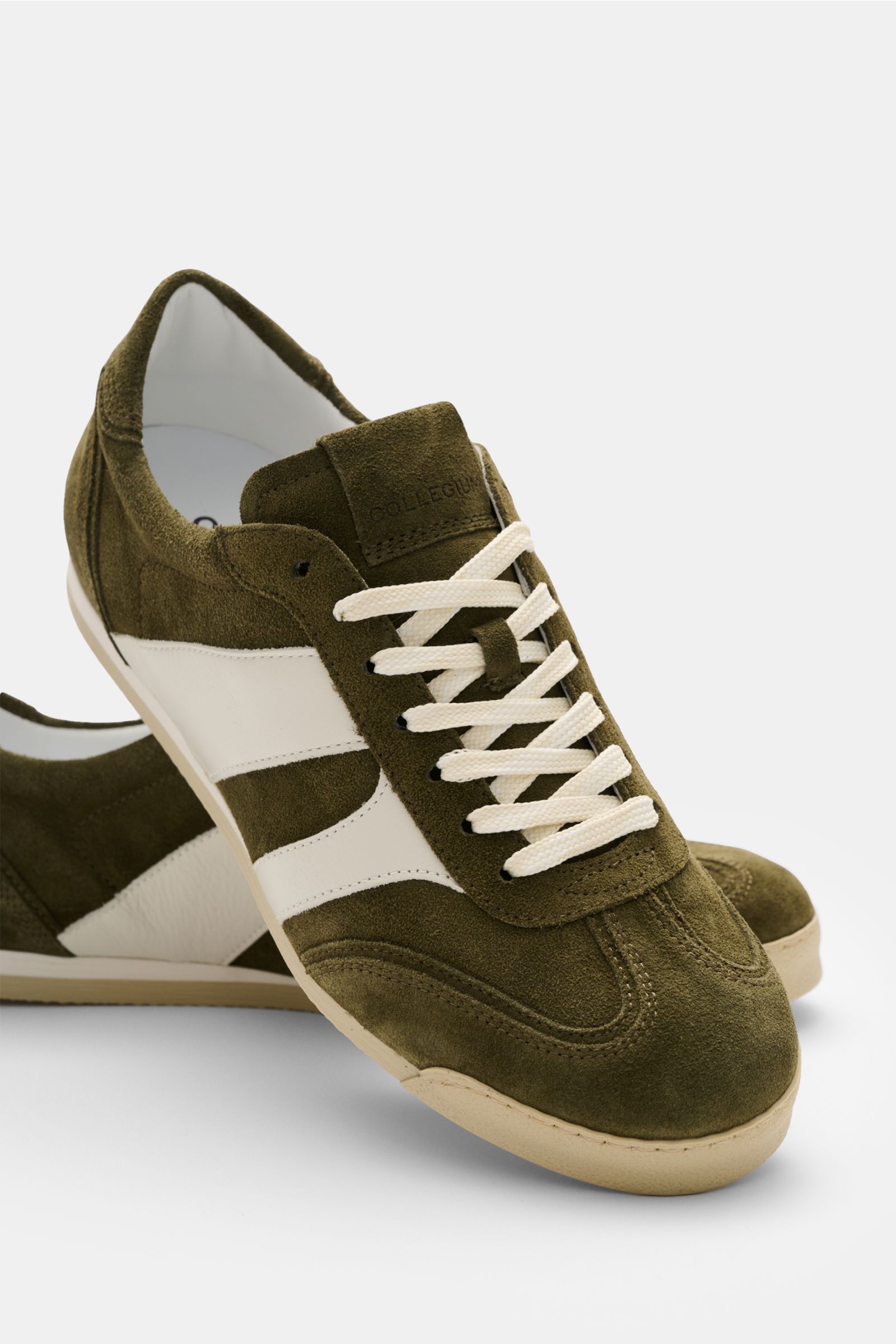 Collegium Sneaker 'Pillar Pista' oliv/offwhite aus Veloursleder, flexible Gummisohle, runde Vorderkappe, 7-Loch-Schnürung, seitliche Leder-Overlays, gepolsterter Schaftrand, Innenfutter aus Leder, frontal und seitlich fotografiert.