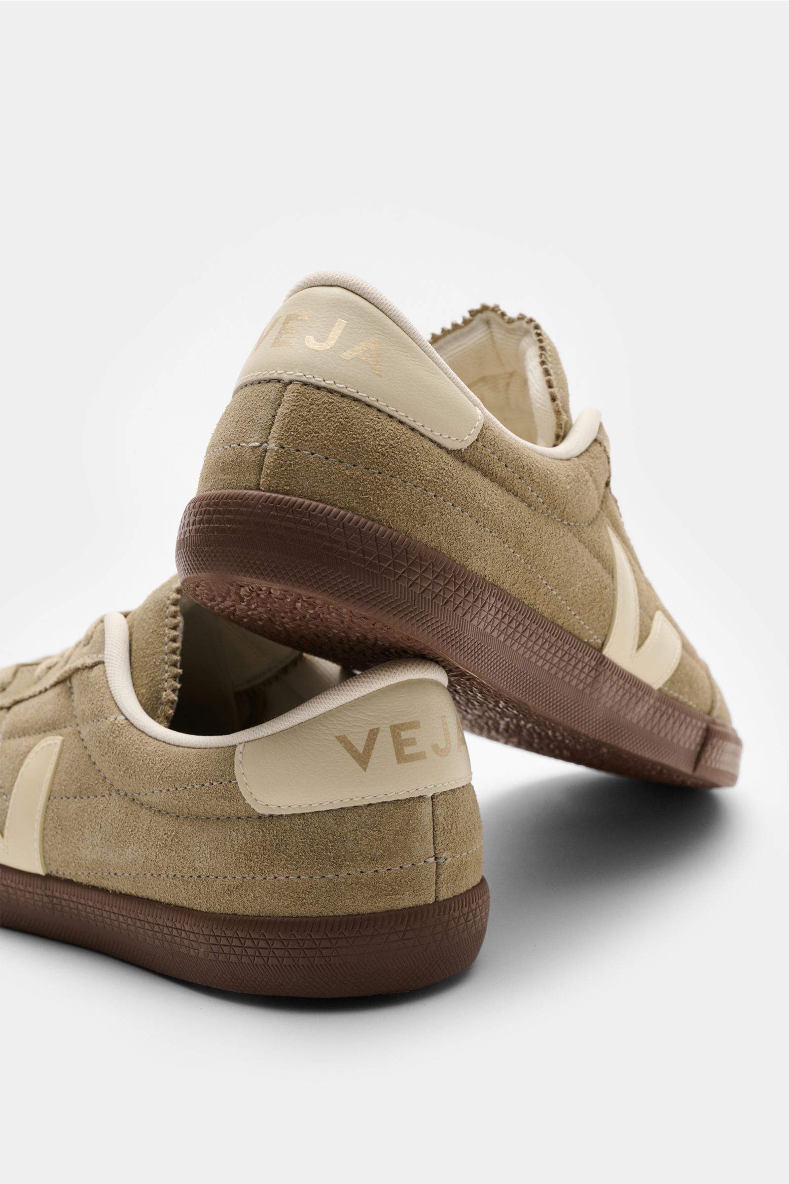 Veja Sneakers 'Panenka' taupe/cream shown from rear side perspective, featuring smooth suede, leather overlays, six-eyelet lacing, V-overlay, padded topline with logo, logo print tongue, textile lining, and flexible rubber sole. The sneakers 'Panenka' by 