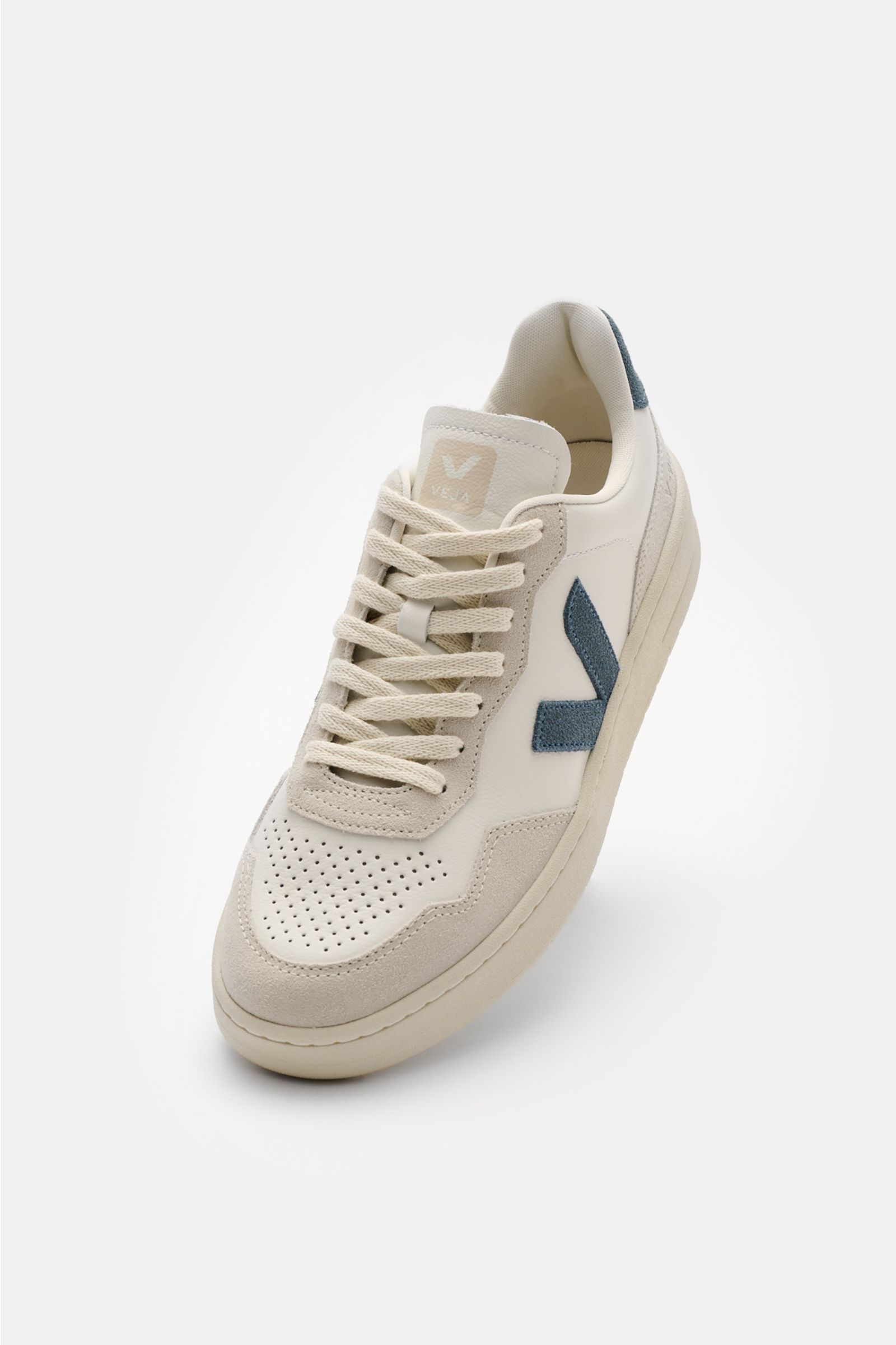 Front angled view of Veja Sneaker 'V-90 O.T. Leather' offwhite/hellgrau/graublau, made from sustainable leather with perforated toe, seven-hole lacing, padded collar with logo, tonal V-overlay, jersey lining, and recycled rubber sole.