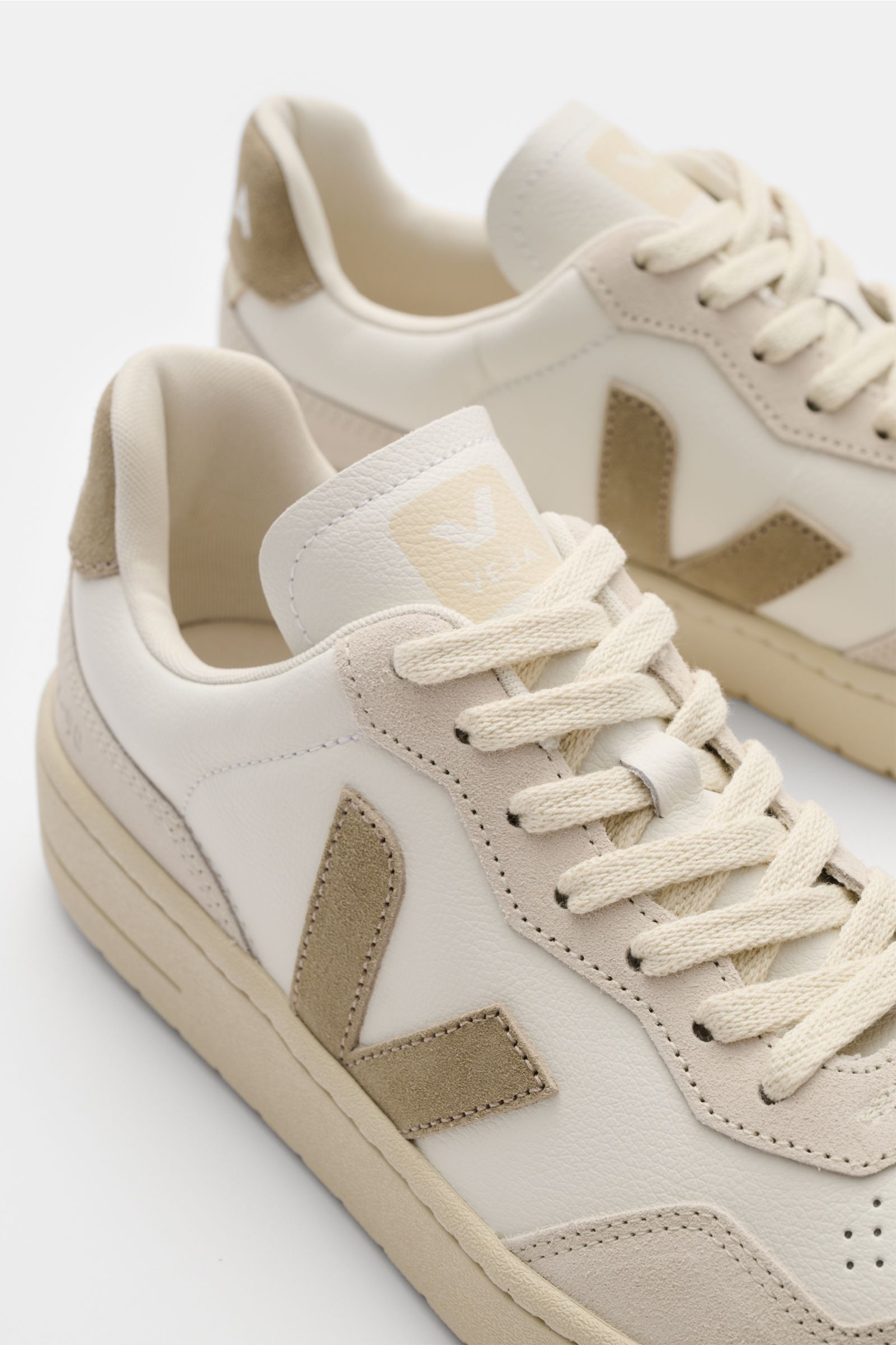 Veja Sneaker 'V-90 O.T. Leather' offwhite/taupe, seitliche Nahaufnahme, nachhaltiges Leder, V-Overlay, Perforationen, recycelte Kautschuksohle.