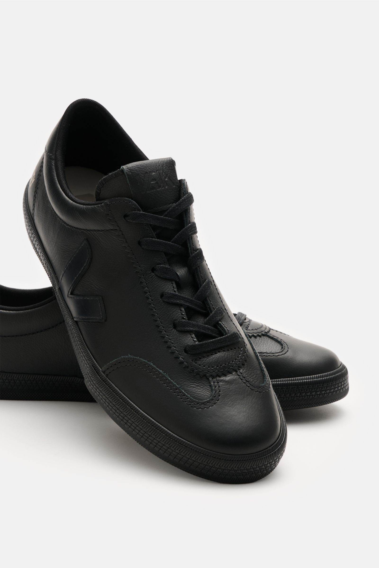 Veja Sneaker 'Volley O.T. Leather' schwarz, seitliche und frontale Ansicht, aus fein genarbtem Organic Traced Leder mit V-Overlay.