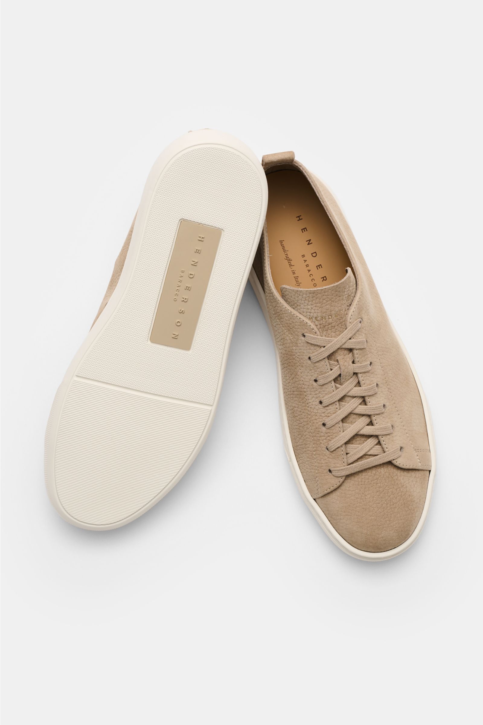 Top-down view of Henderson Sneaker 'Thomas' taupe showing soft brushed leather, round toe, seven-hole lacing, logo embossing on tongue, leather lining, pull tabs, and light rubber sole. Ultra leichte handwerkliche Perfektion: Der Sneaker 'Thomas' von HEND