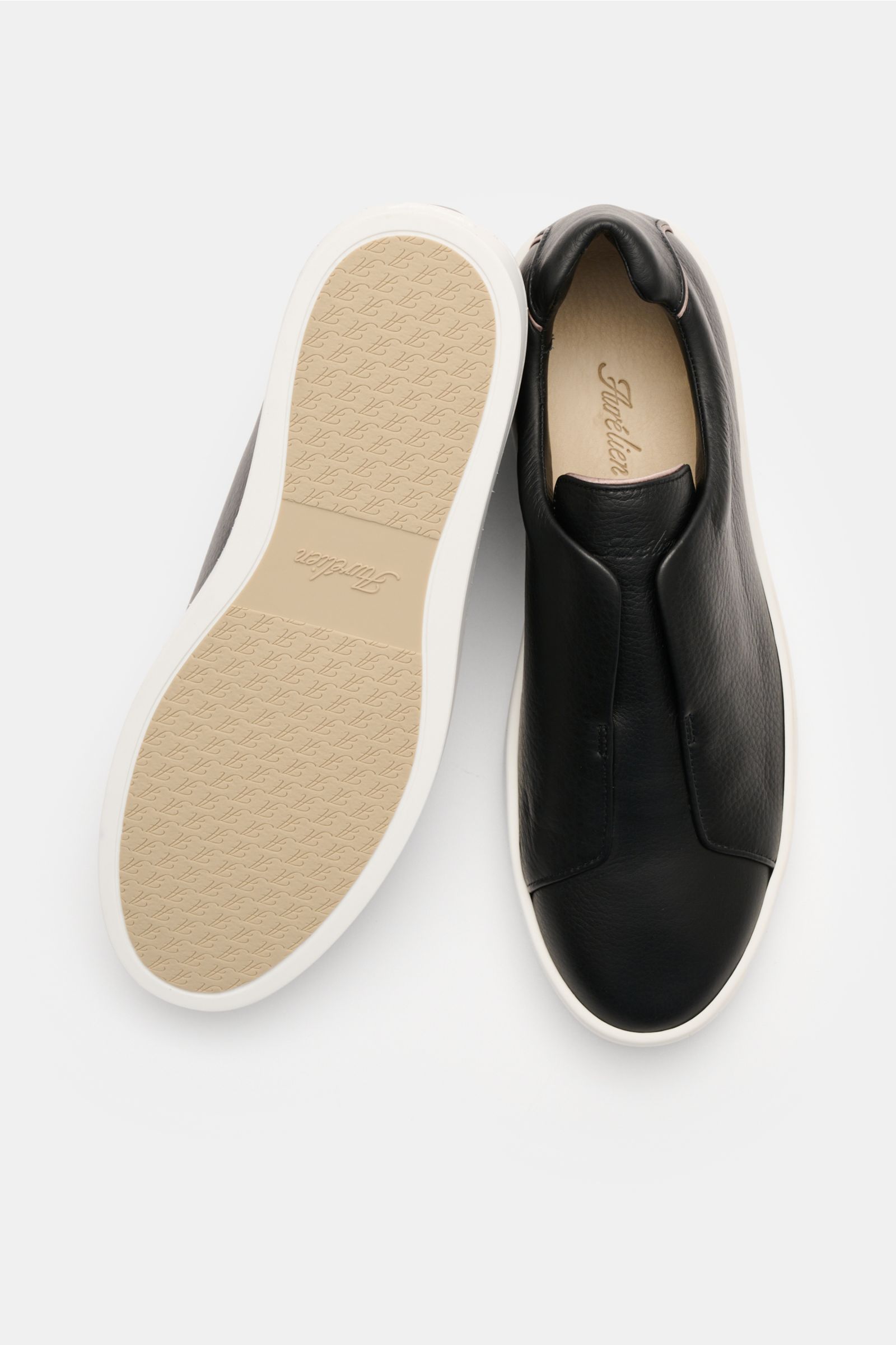 Aurélien Slip-on-Sneaker schwarz, oben und Sohle von unten gezeigt, fein genarbtes Leder, runde Vorderkappe, elastische Bänder, Lederfutter, Gummisohle.