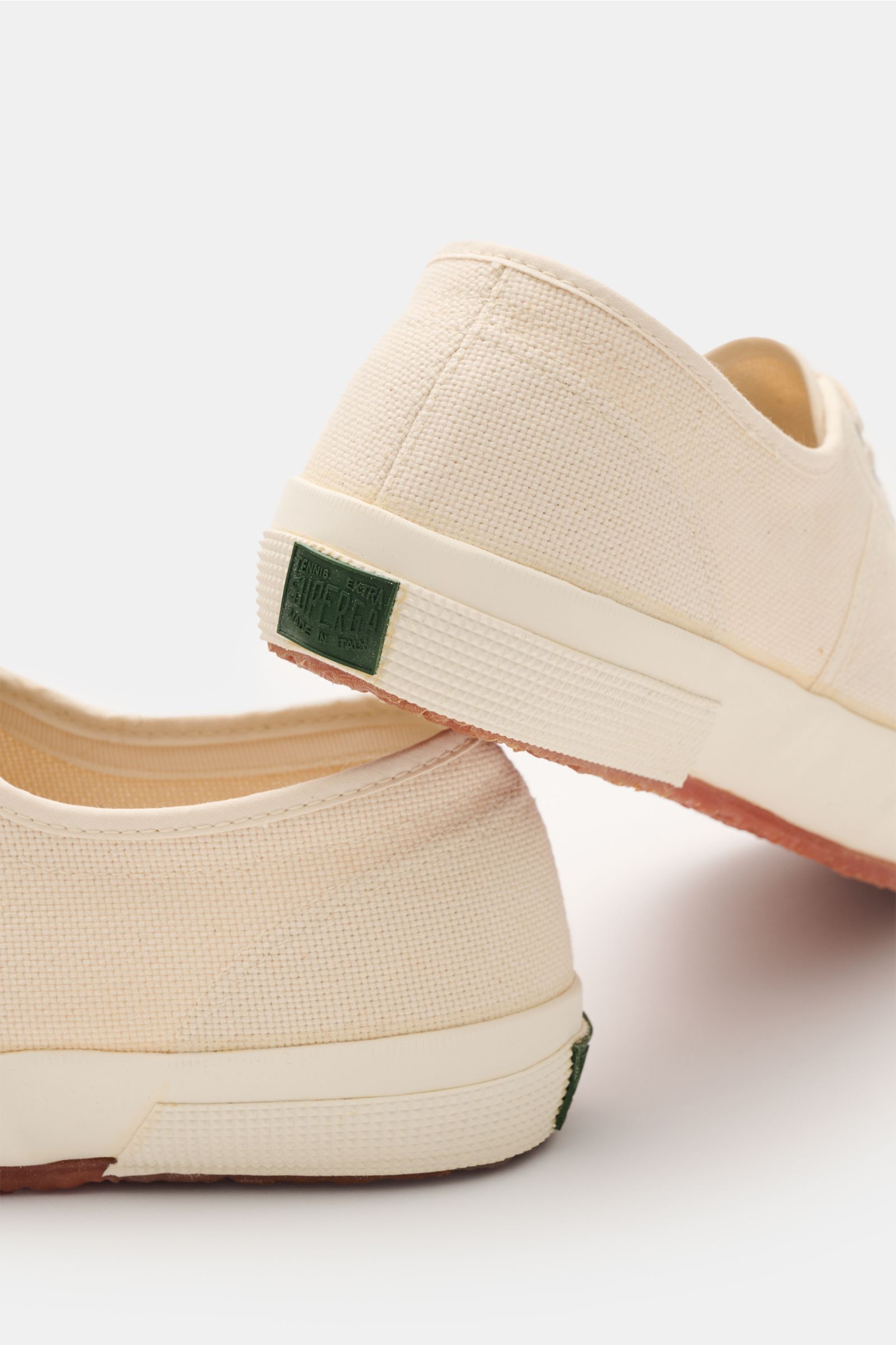 Superga Sneaker 'Cotu Classic' creme/offwhite aus robustem Baumwoll-Canvas, sechs-Loch-Schnürung, Innenfutter Baumwolle, flexible Gummisohle, seitliche Nahaufnahme von hinten.