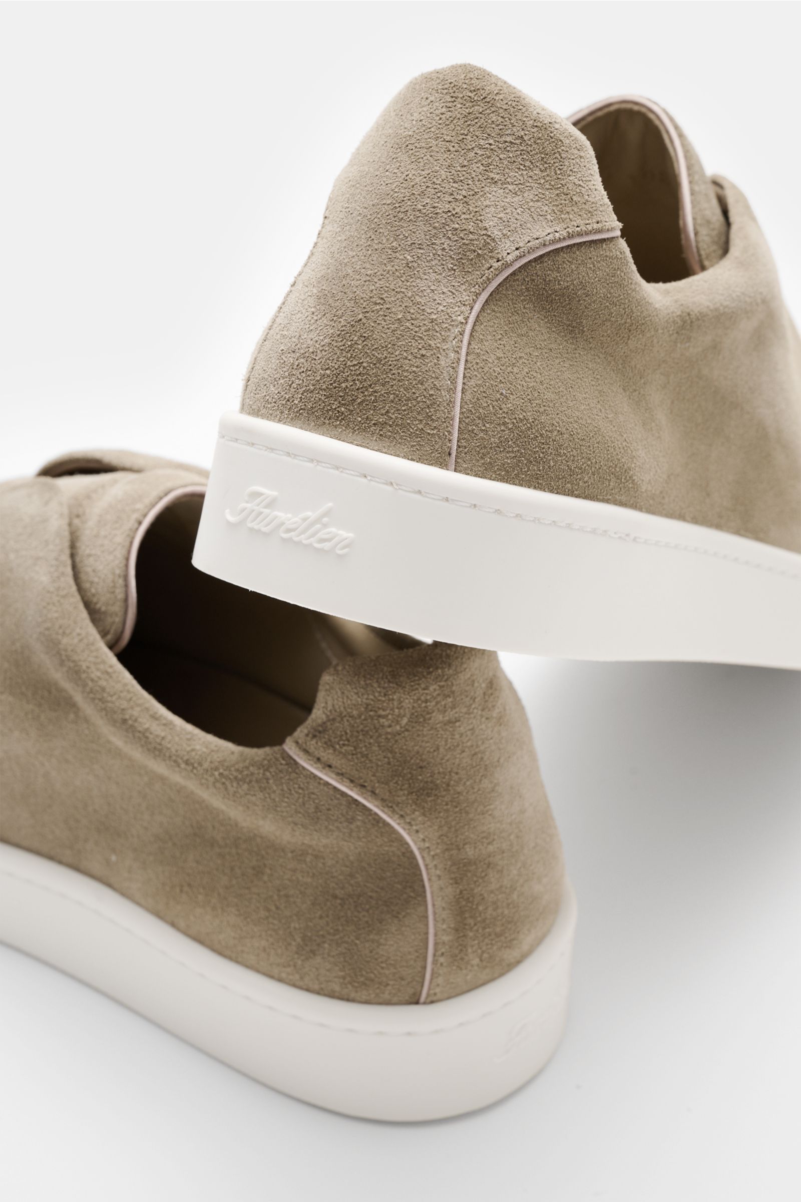 Aurélien Slip-on-Sneaker taupe aus softem Veloursleder, runder Vorderkappe, elastischen Bändern, gepolstertem Schaftrand, Lederfutter, flexible Gummisohle, von hinten fotografiert.