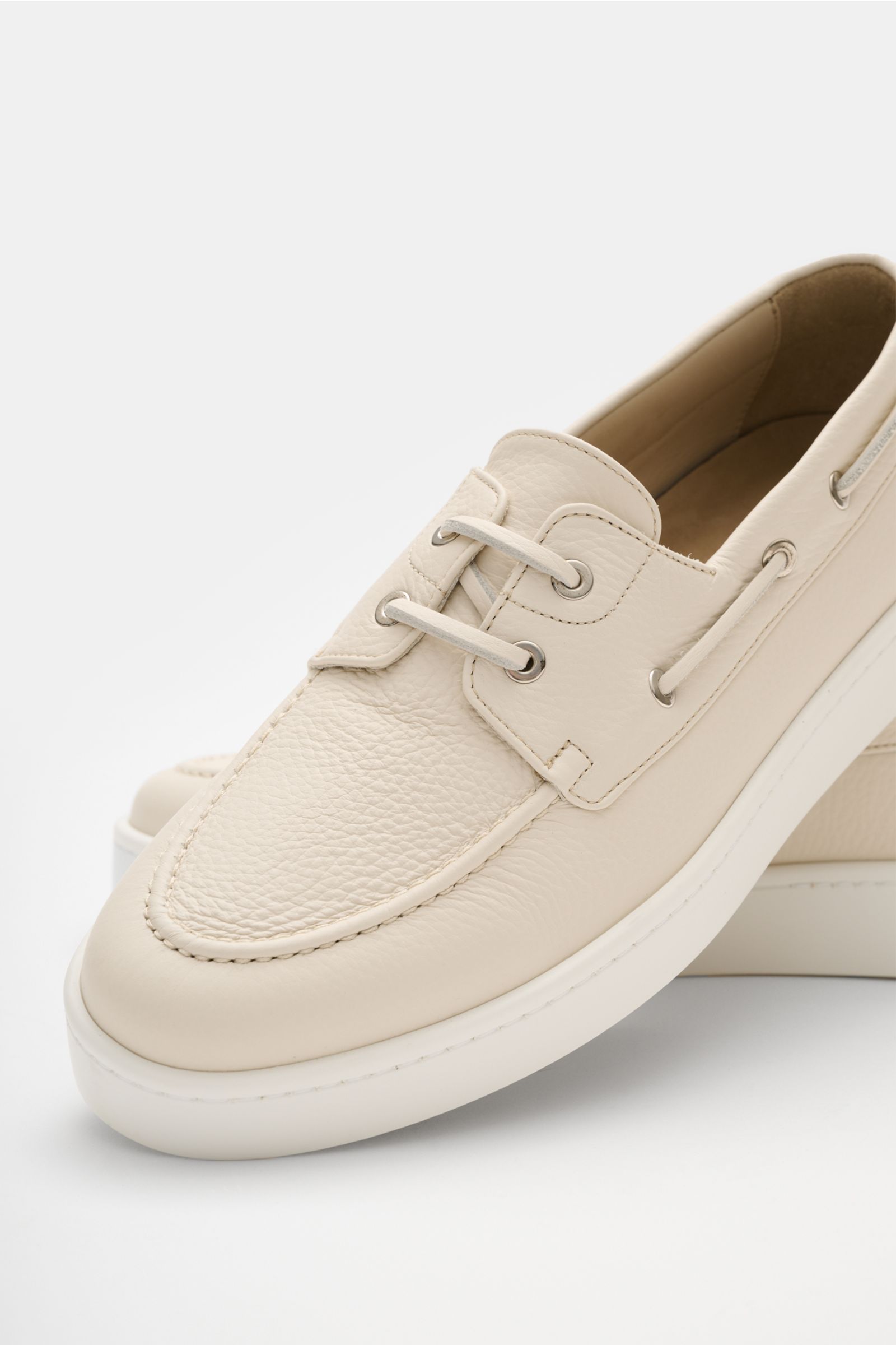 Aurélien Bootsschuh 'Boat Sneaker' creme, genarbtes Leder, schmal zulaufende Silhouette, Naht auf Vorderkappe, ledernes Innenfutter, flexible Gummisohle, seitliche Nahaufnahme.