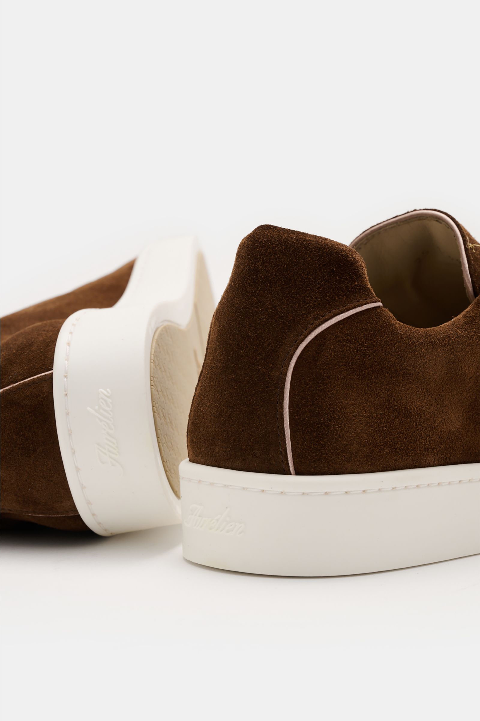 Aurélien Slip-on-Sneaker braun aus softem Veloursleder, runde Vorderkappe, elastische Bänder, hoher Schaftrand, Lederfutter, flexible weiße Gummisohle, seitliche Nahaufnahme von hinten.