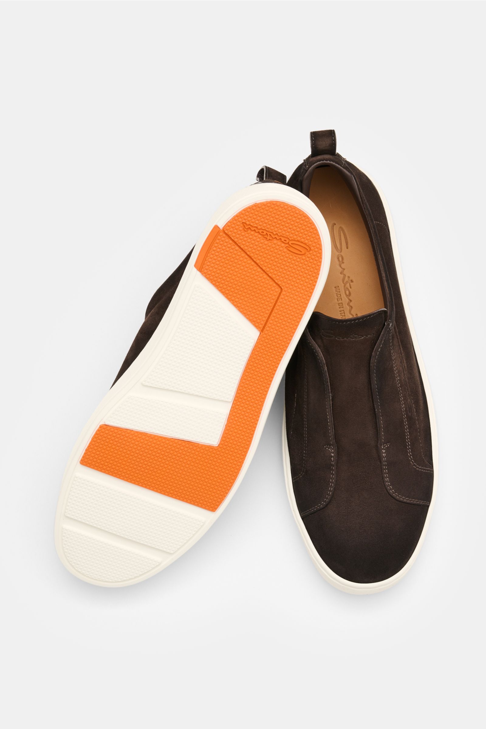 Top view of Santoni Slip-on-Sneaker 'Victory' dunkelbraun in dark brown suede with orange and white lightweight rubber sole, showing soft velour leather, slim tapering, elastic gusset, subtle logo embossing, pull tab, leather lining, and practical pull lo