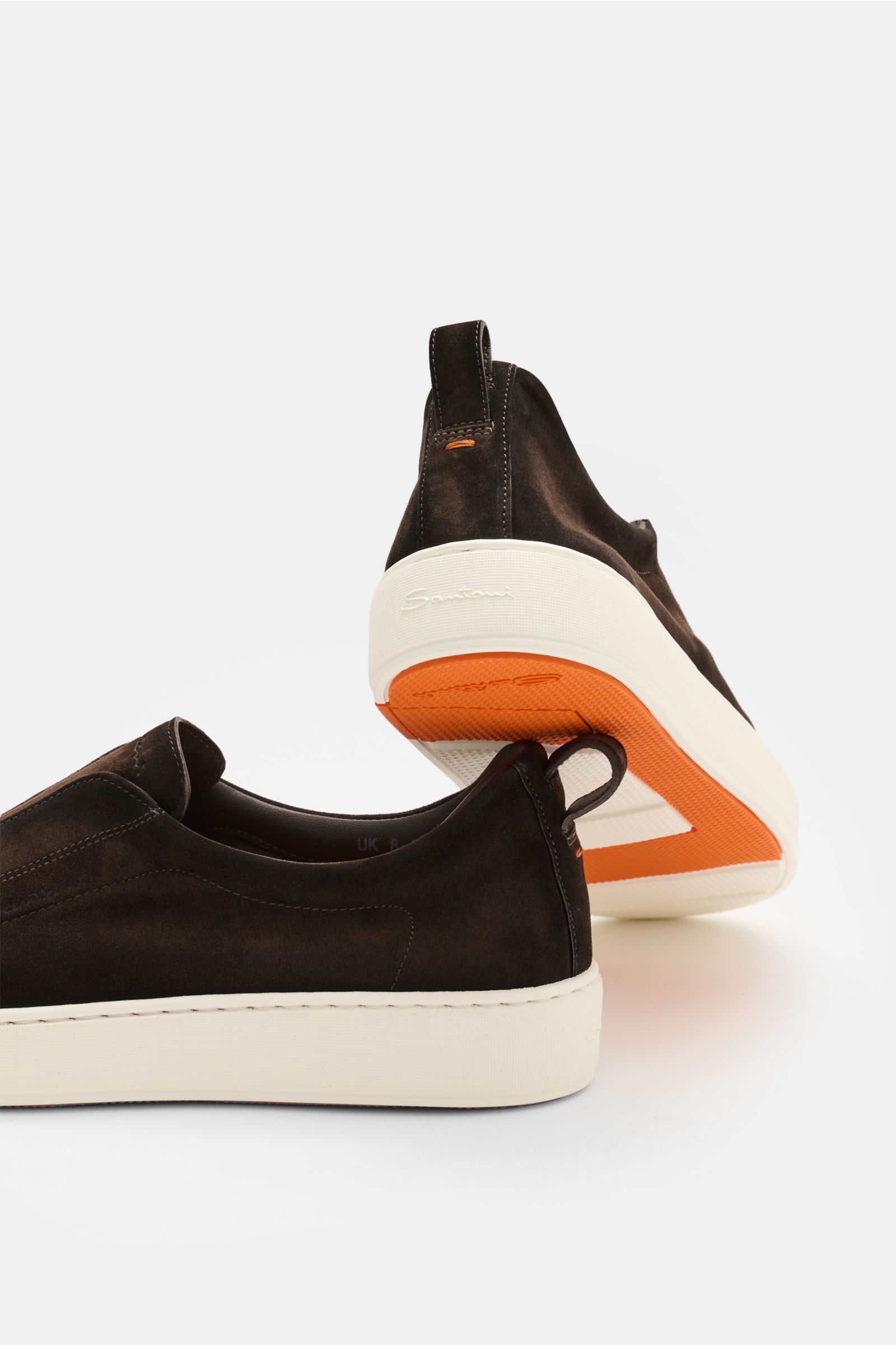 Rear and side view of Santoni Slip-on-Sneaker 'Victory' dunkelbraun in dark brown velour leather with white sole and orange outsole.

SANTONI kann auch praktisch und zugleich komfortabel sein: Der Slip-on-Skneaker 'Victoy' aus geschmeidigem Velourslede