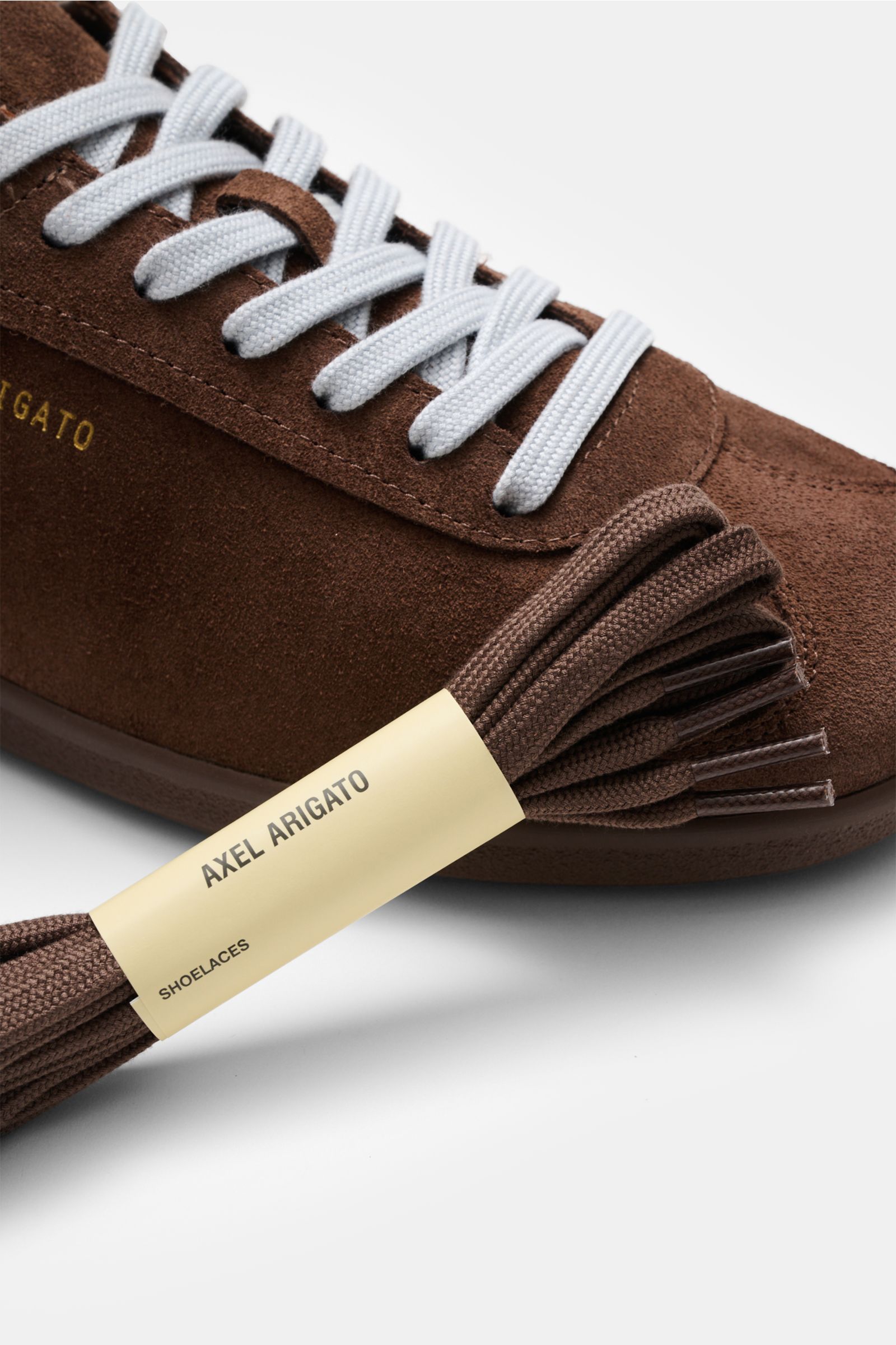 Axel Arigato Sneaker 'Zane' braun aus Veloursleder, Nahaufnahme seitlich von oben mit weißen Schnürsenkeln und Ersatzschnürsenkeln.